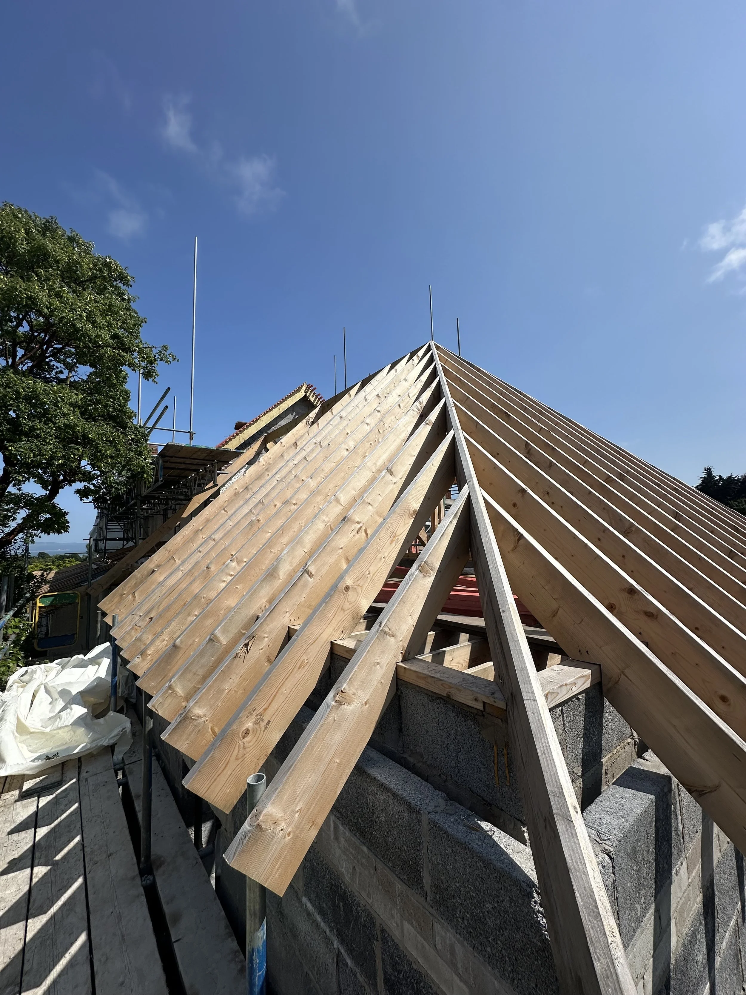Timber roof trusses installed on pitched roof structure