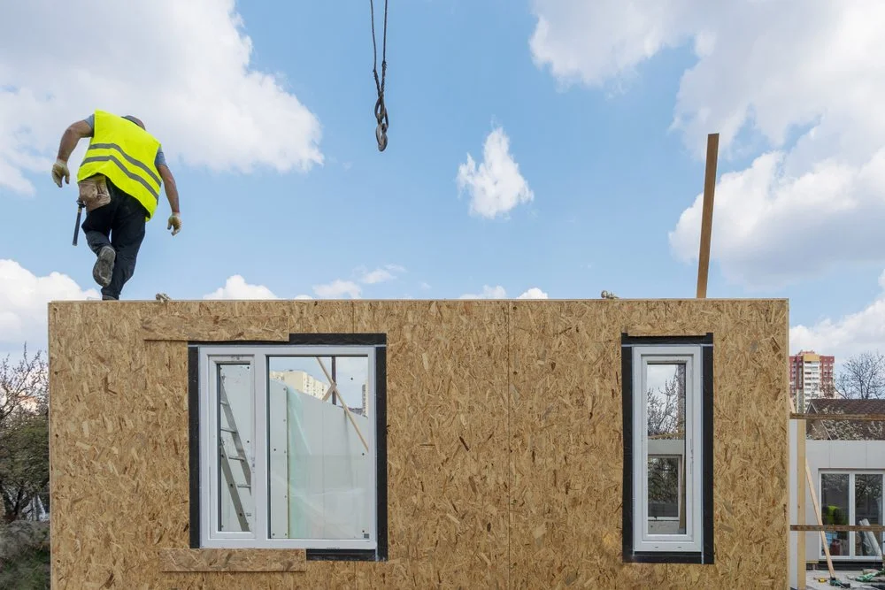 Prefabricated timber frame panels being installed on building structure