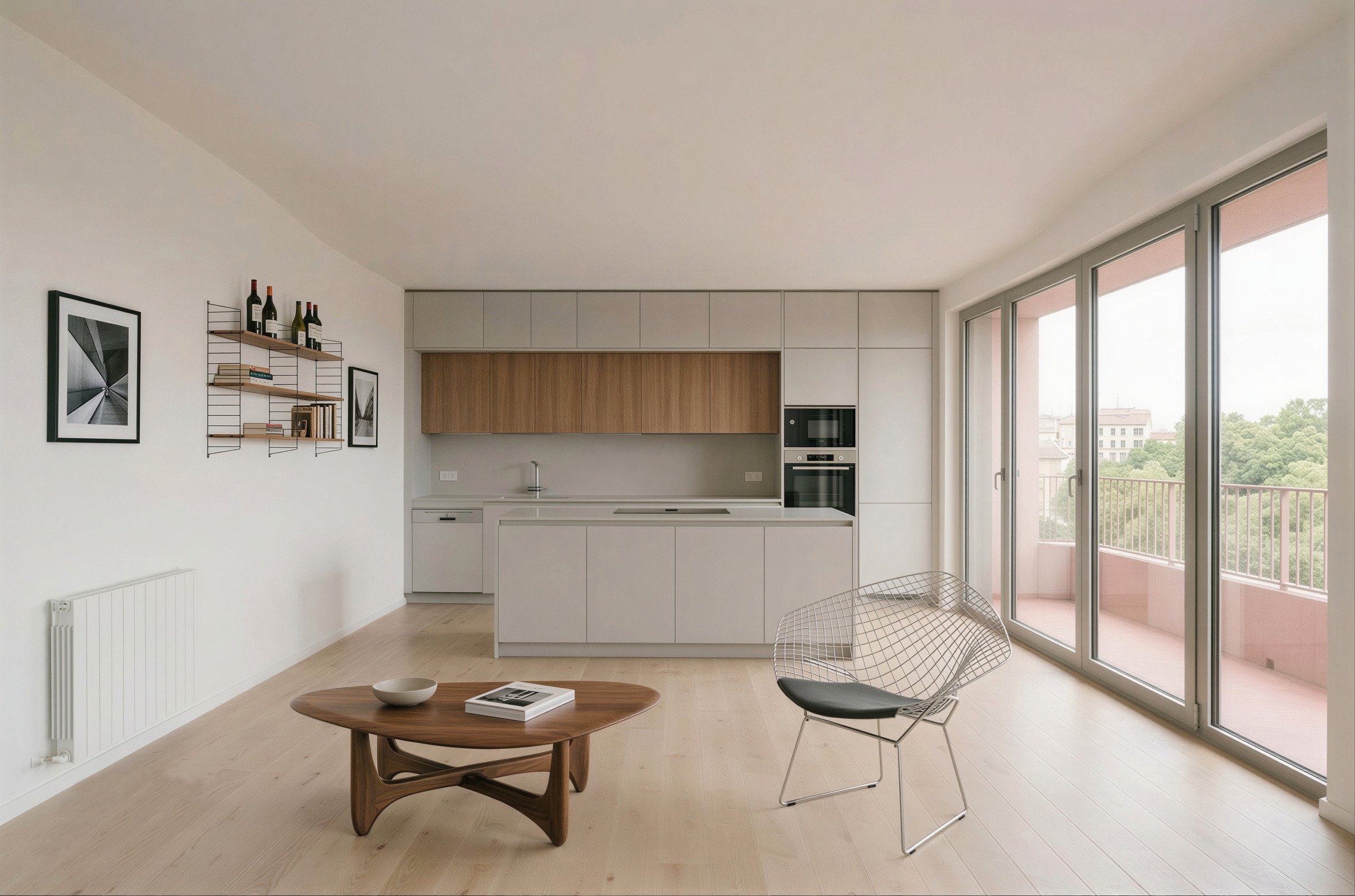 Intérieur moderne d'une cuisine ouverte avec grands fenêtres donnant sur un balcon, mobilier minimaliste, et une table ronde en bois avec des chaises en métal.