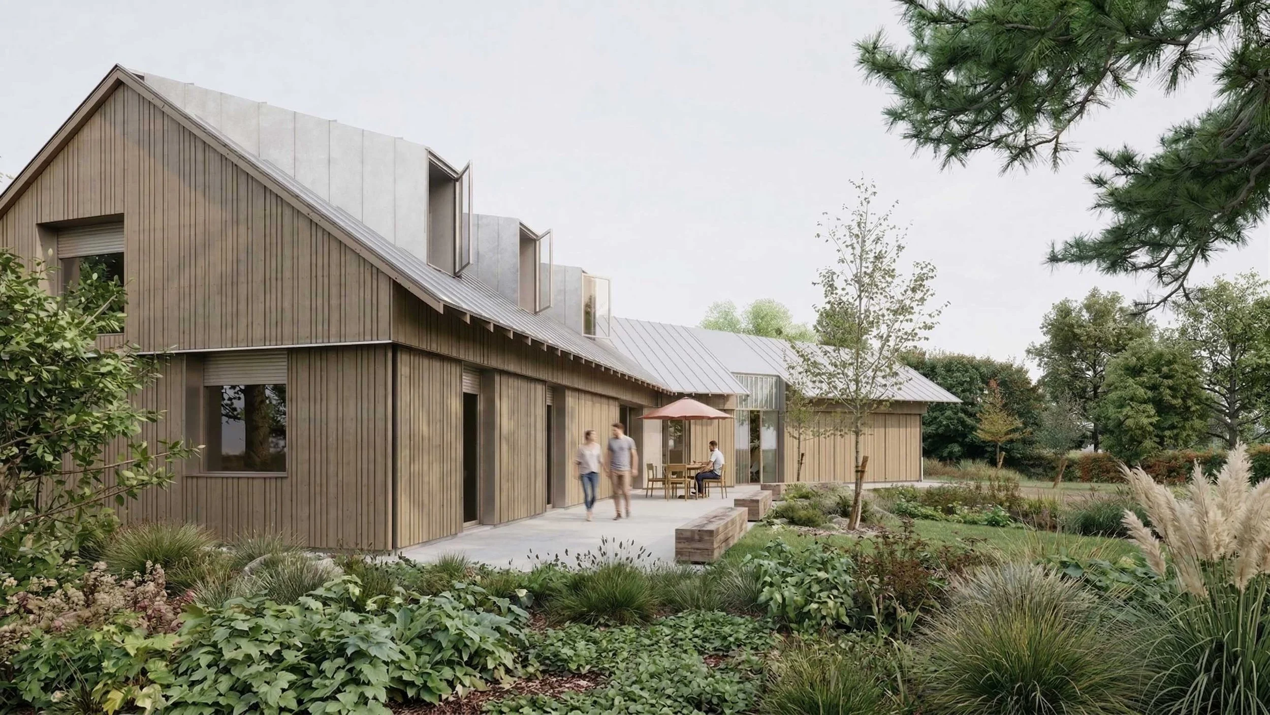 Une maison moderne en bois avec un toit en zinc, entourée d'un jardin verdoyant et de personnes assises à une table sous un parasol.