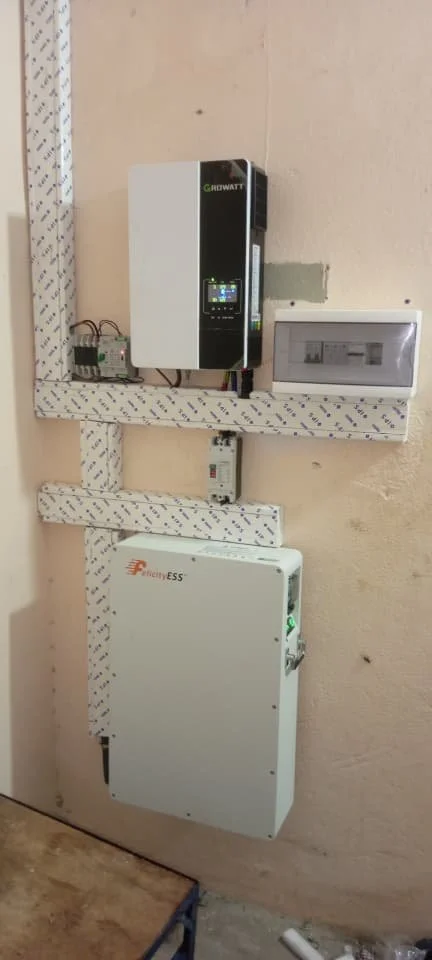 Installation électrique avec un onduleur, un boîtier électrique, et un contrôleur sur un mur.