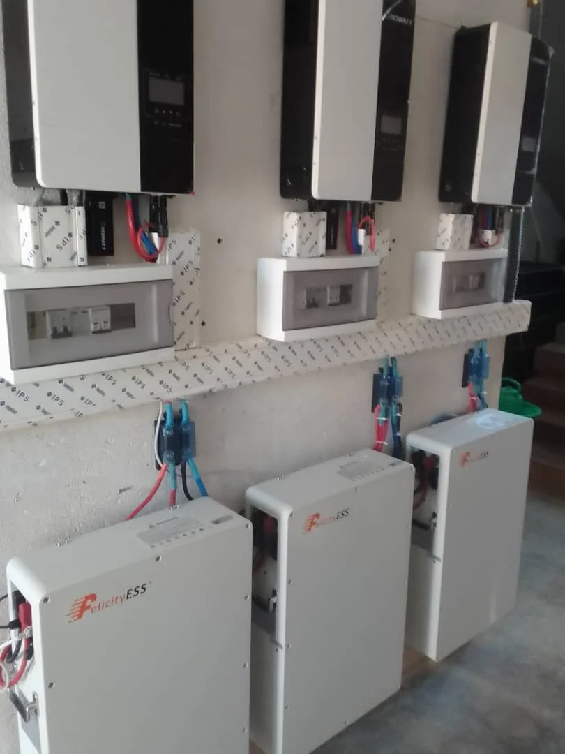 Installation électrique avec trois onduleurs et trois contrôleurs de charge, câblage organisé sur une planche.