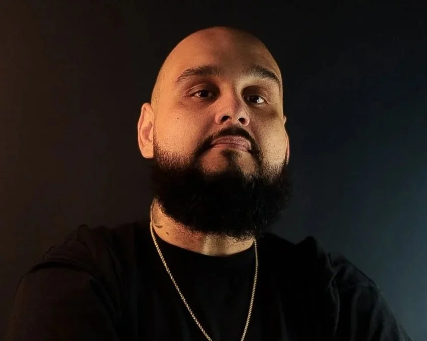 Bearded man with black shirt and gold necklace