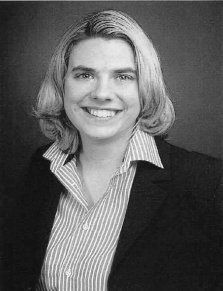 Schwarz-weiß Portrait eines lächelnden Frau mit kurzen, geraden Haaren, in formeller Kleidung