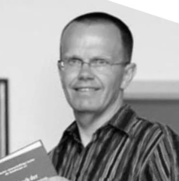 Porträt eines Mannes mit Brille, der ein Buch hält, in Schwarz-Weiß.