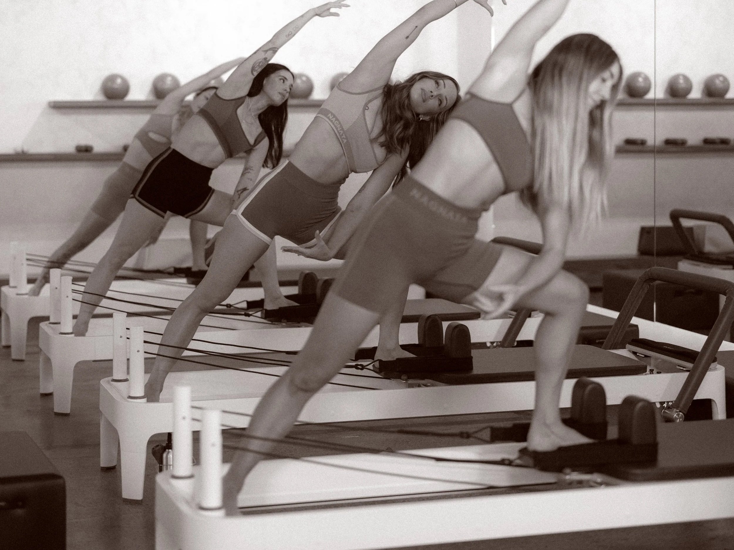 Small group reformer Pilates class at Aligne Studio, focused on precise, instructor-led movement.