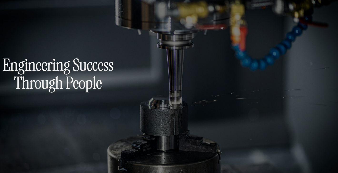 Close-up of a CNC machine drilling into a metal component, with the text 'Engineering Success Through People' overlaid.