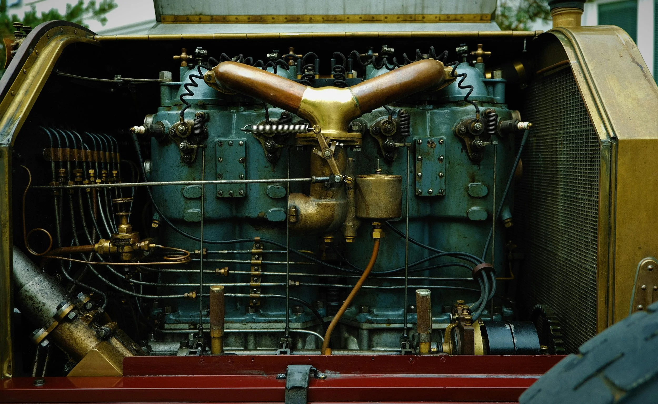 Close-up of vintage automobile engine with exposed mechanical parts and pipes.