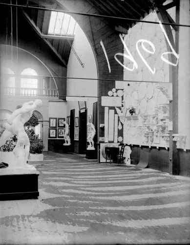 Interior room of the Museum of Art, with paintings, drawings and reliefs on the walls. Photo from the Burton Historical Collection.