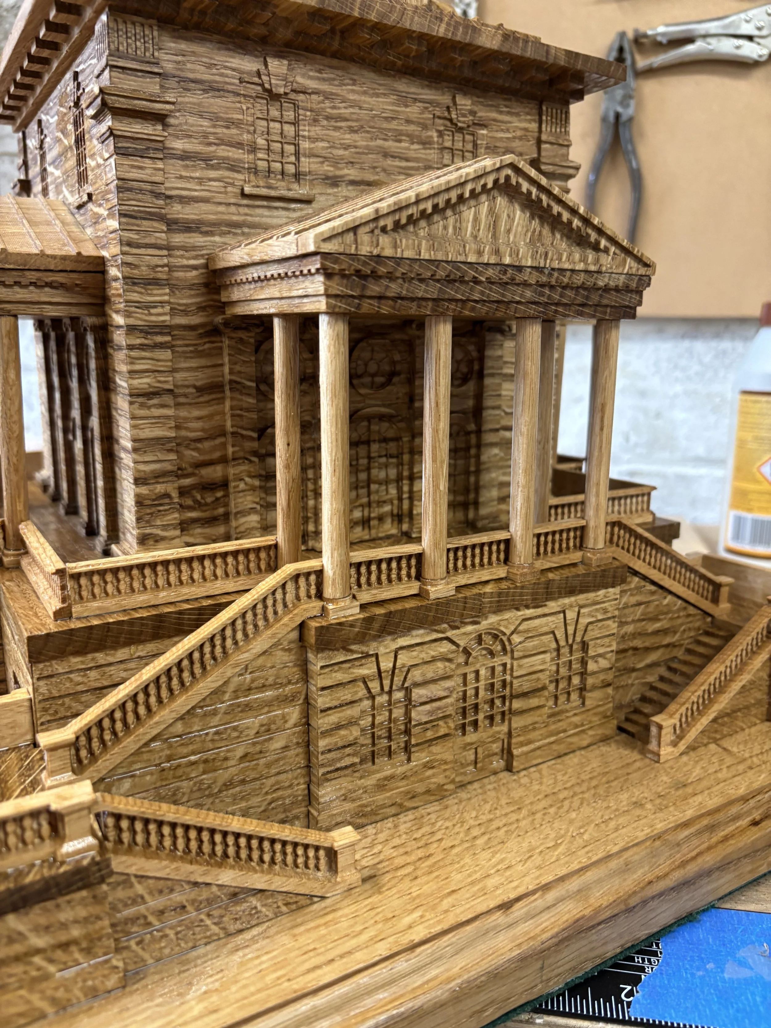 Wooden model of a classical building with columns, stairs, and intricate architectural details.