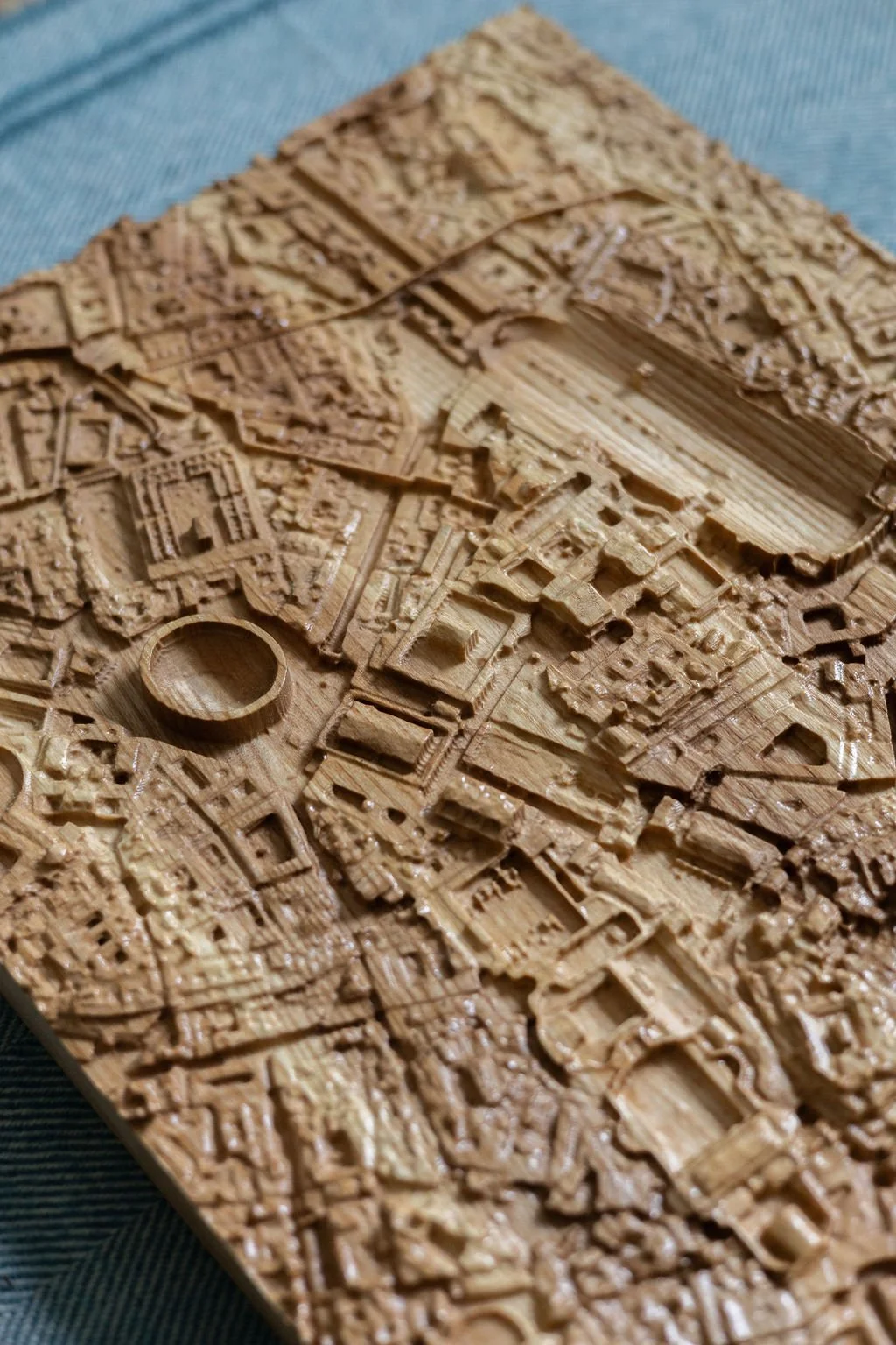 Close-up of a detailed wooden map or model with intricate buildings and structures.