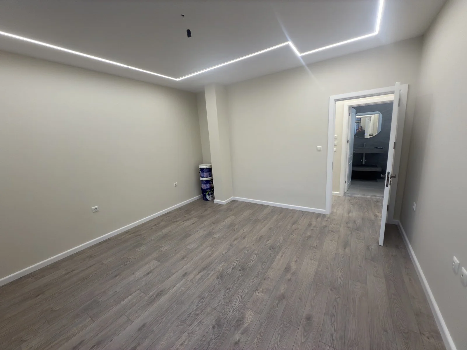 Минималистична ТВ секция с фоново LED осветление, фрезовани панели и светъл ламиниран паркет.