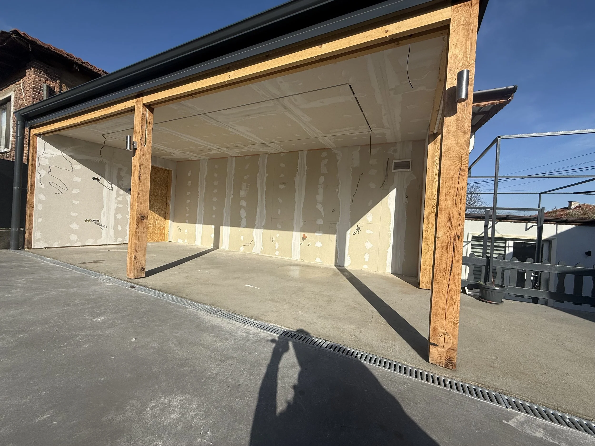 Строителен обект на сграда в Пловдив с недовършени стени и дървени подпорни греди, с отворен гараж или складова зона, дневна светлина – строителство и довършителни работи от PDD Luxury Constructions