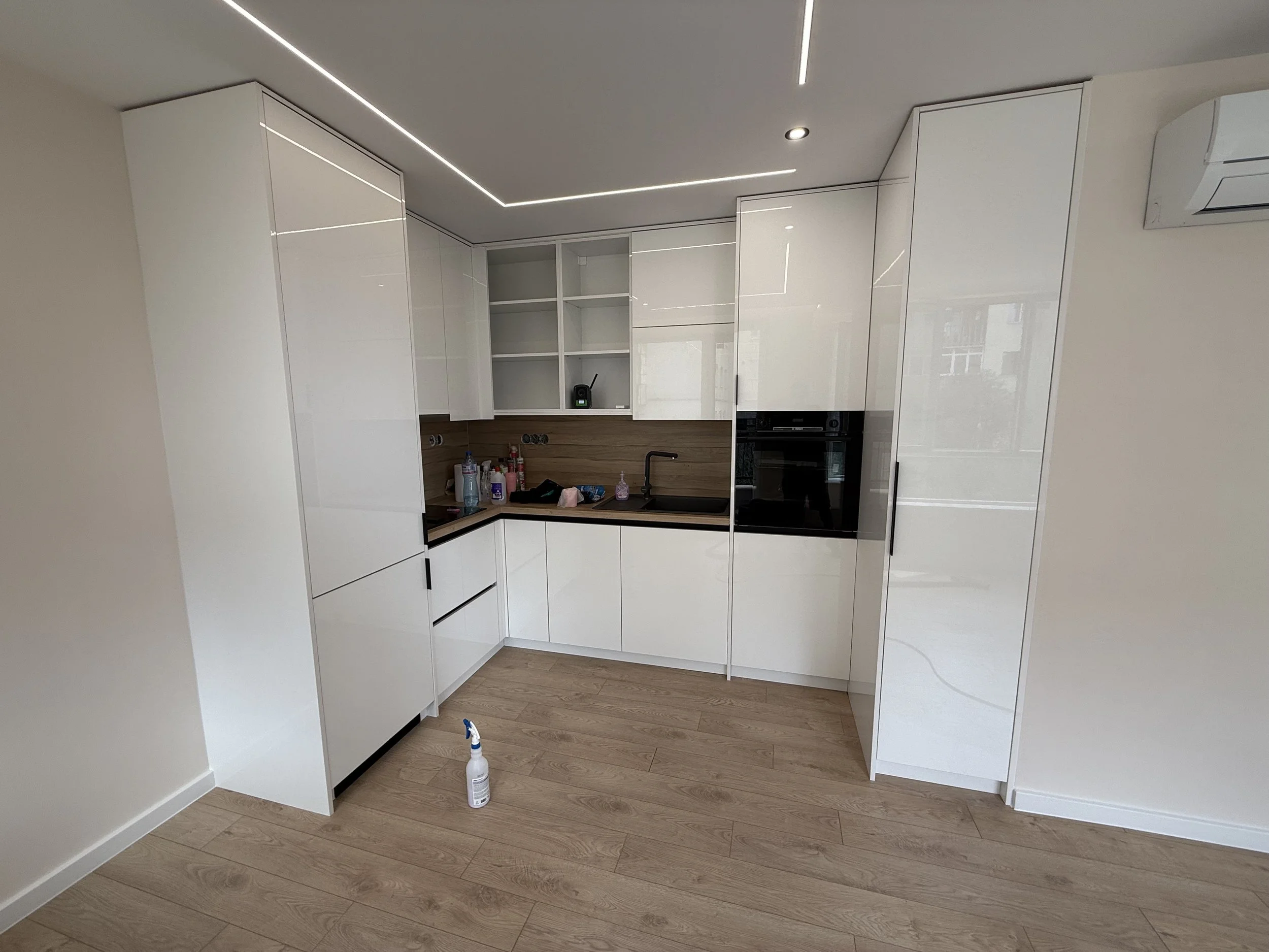 Модерна кухня в Пловдив с бели шкафове, дървени плотове и черна фурна. ремонт и интериорен дизайн от PDD Luxury Constructions