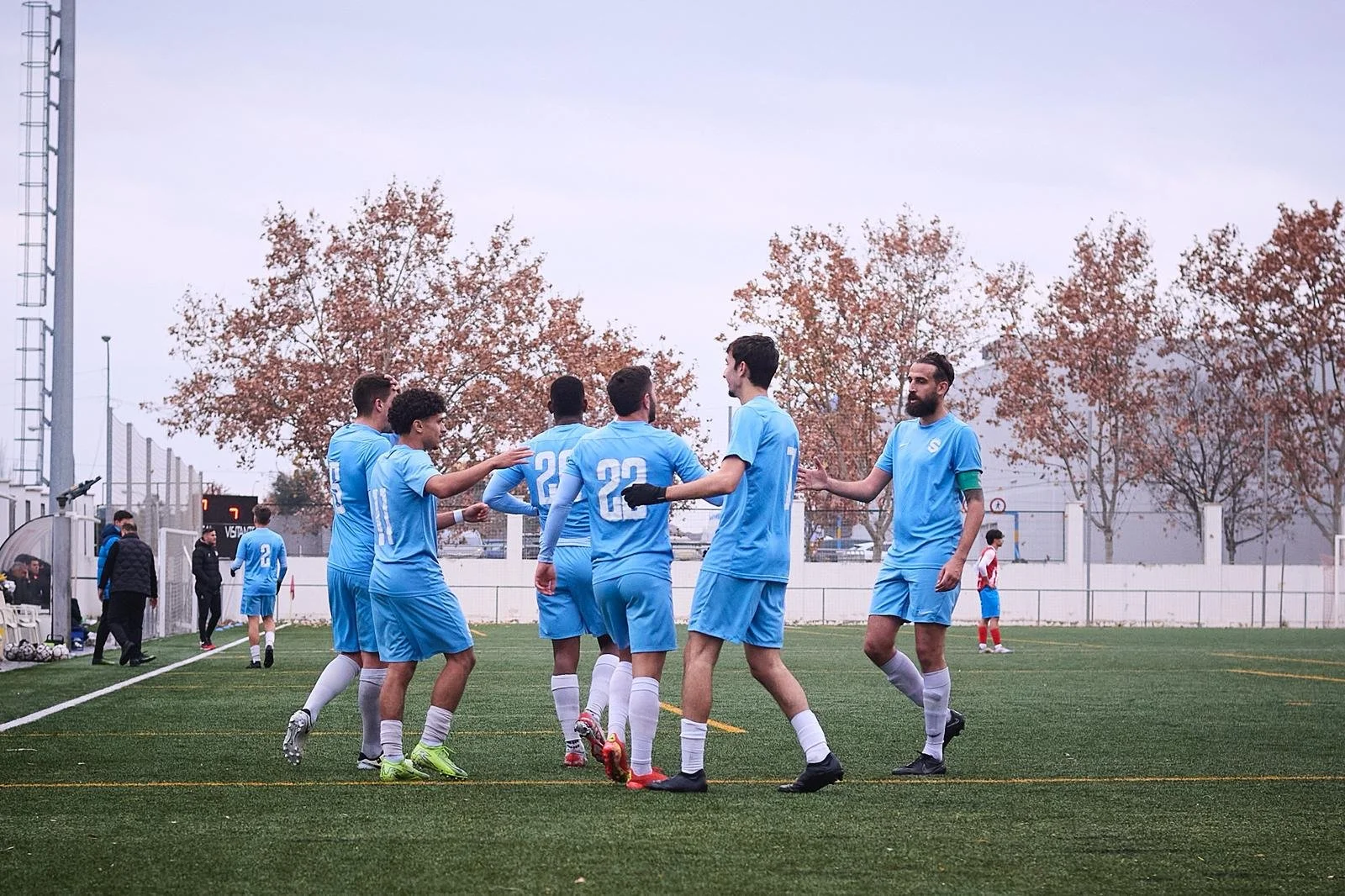 Jugadores de fútbol en campo, celebrando.