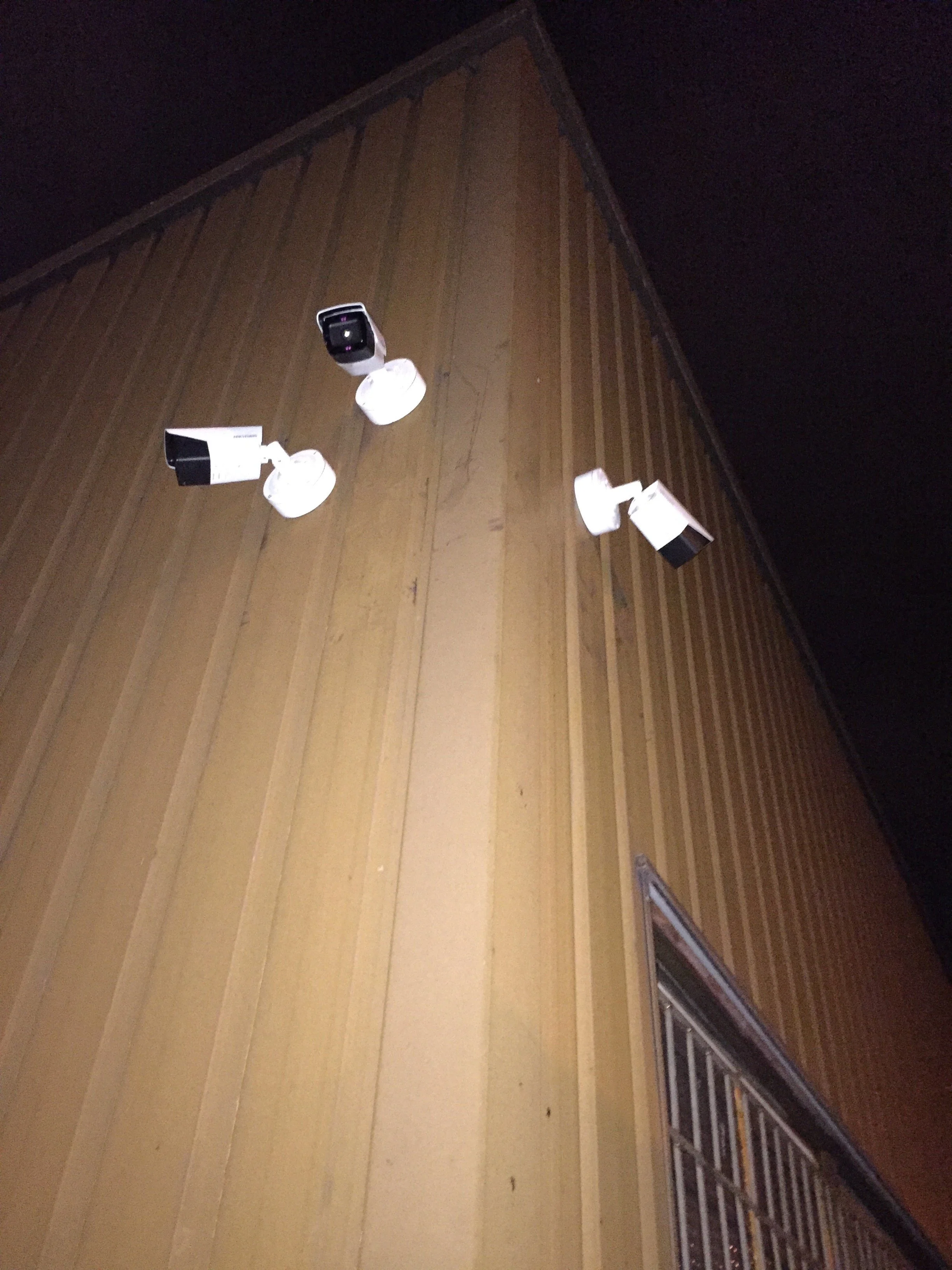 Caméras de surveillance montées sur une façade en bois.