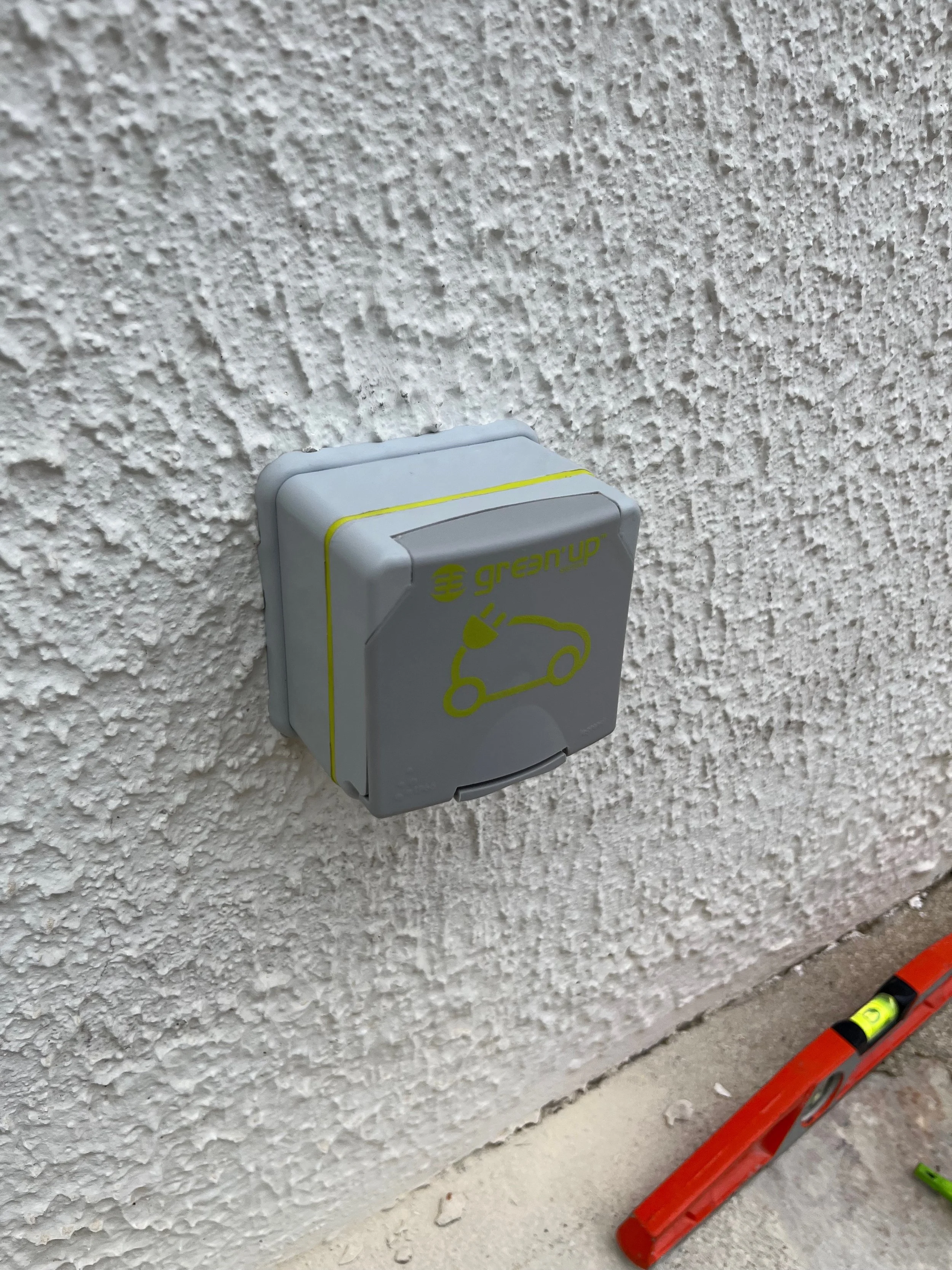 Prise électrique pour voiture électrique, avec logo 'Green'up' et symbole de voiture électrique.