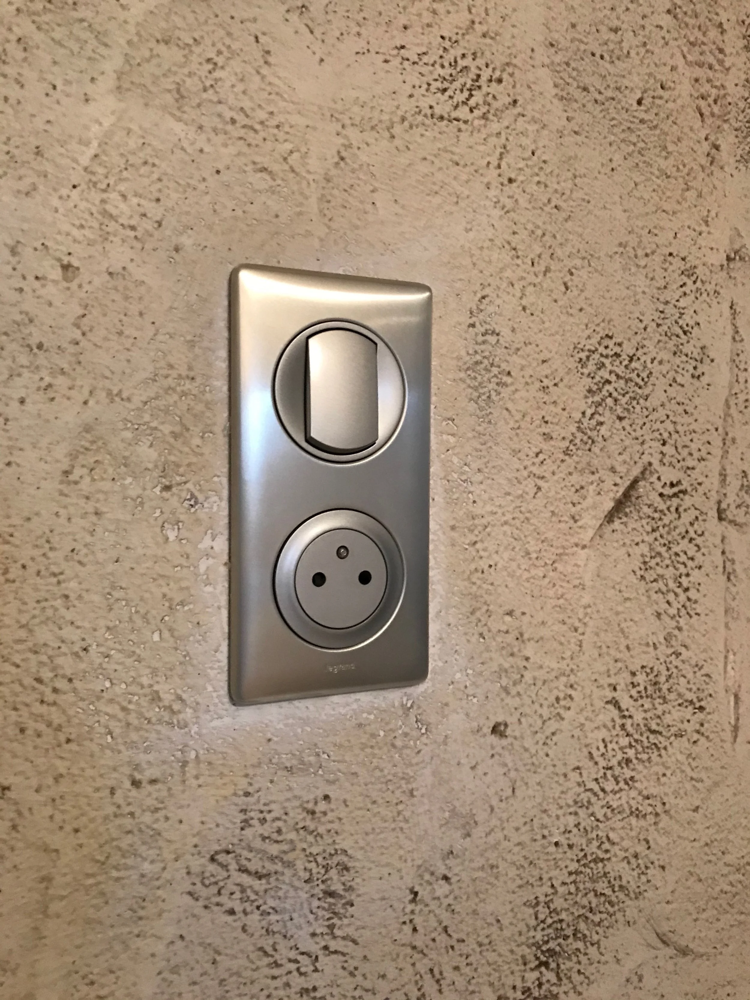 Prise électrique en métal avec interrupteur sur un mur en béton