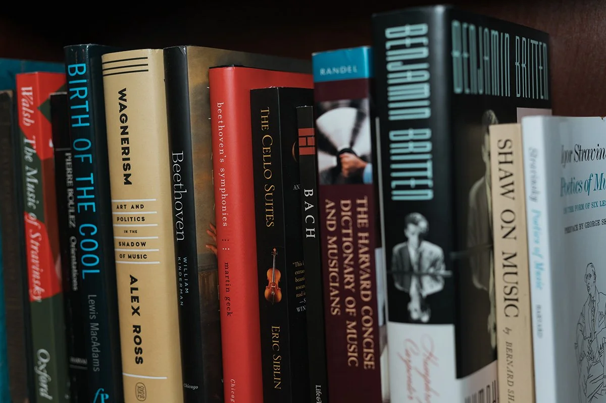 Shelf of books about music and art, including titles like "The Oxford History of the British Song", "Beethoven", "Shaw No Music", and others.