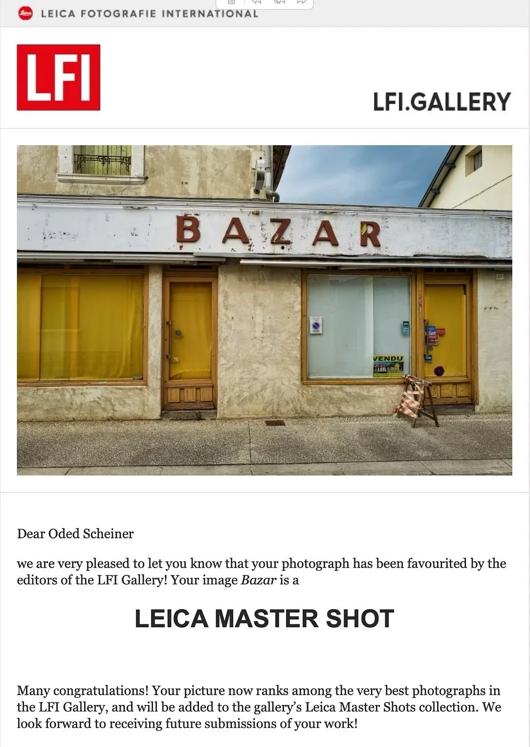 Une façade de magasin avec une enseigne en lettres marron Gucci, les fenêtres ont des stores jaunes, il y a une porte en bois et un panneau "VENDU" dans la fenêtre.