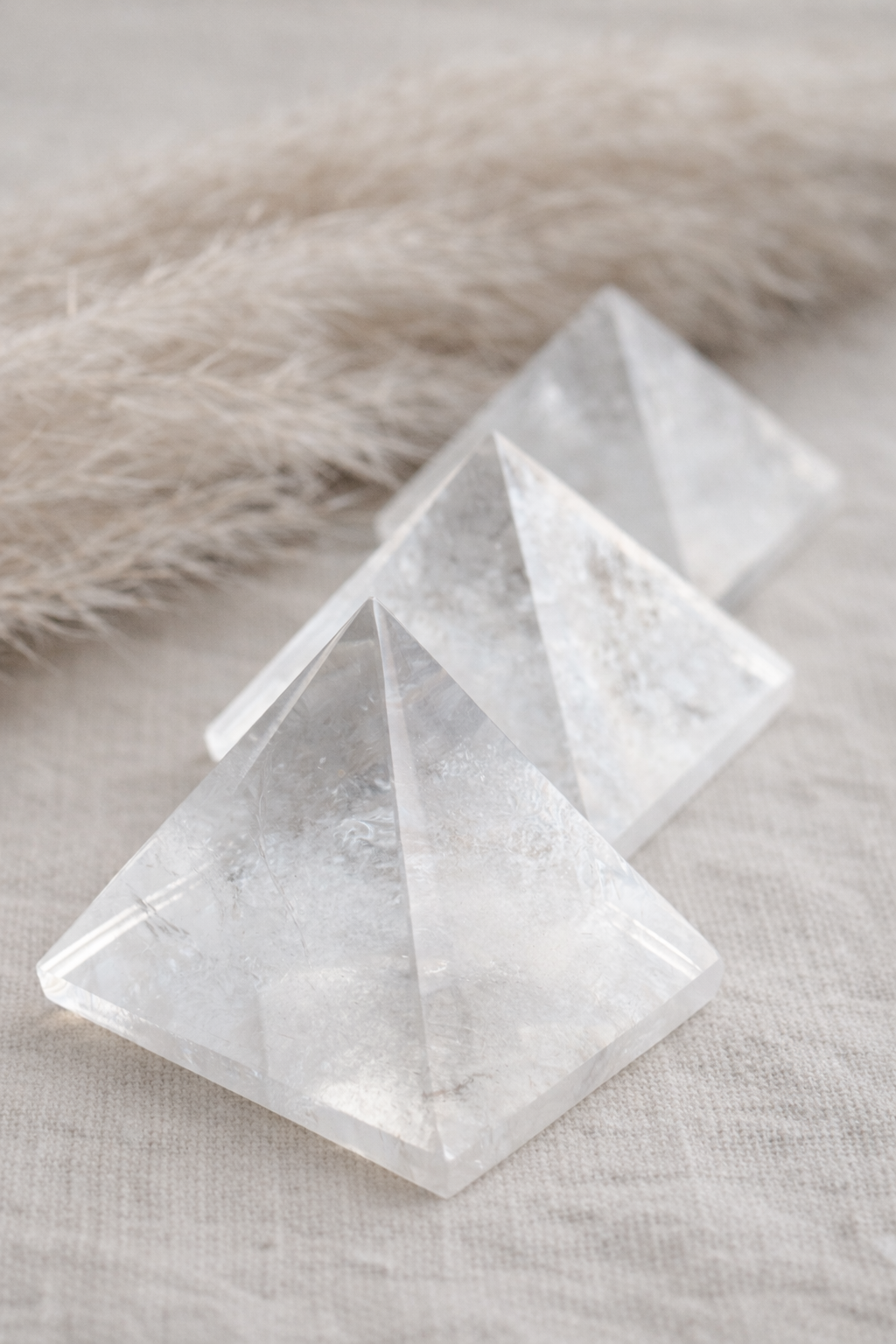 3 Clear quartz pyramids on linen fabric.png