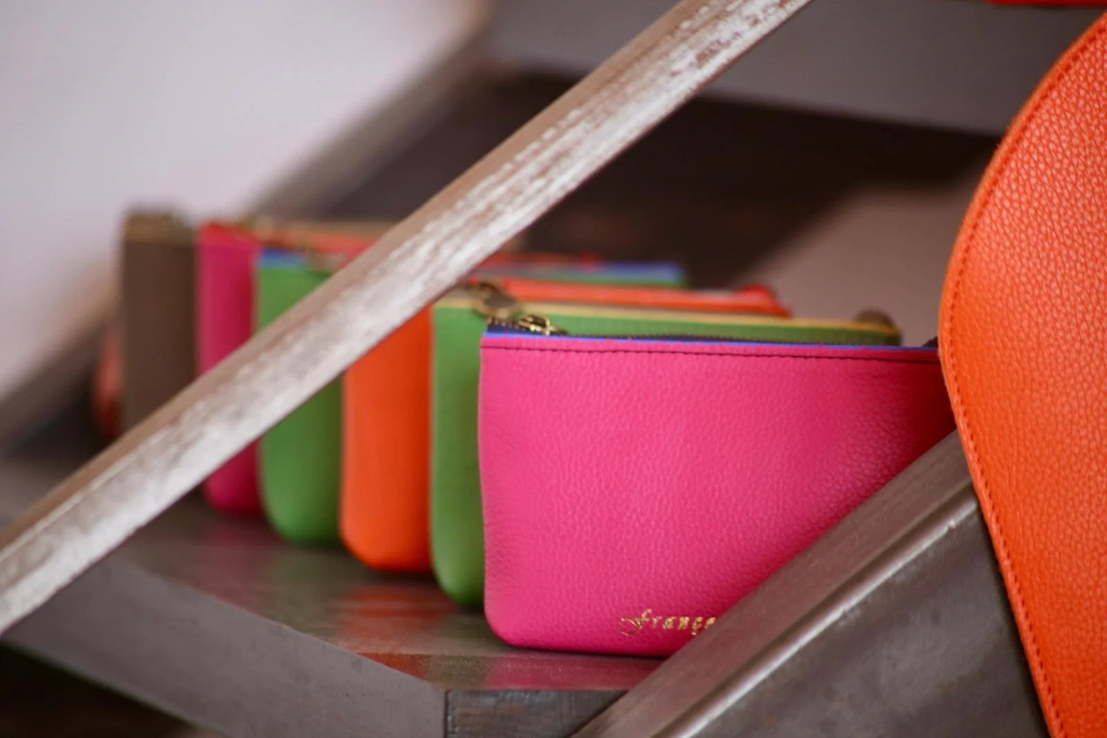 Colorful Françoise small leather wallets with zips on a shelf.