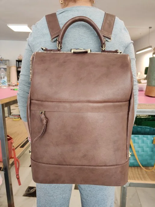 Person with a large brown custom leather backpack.