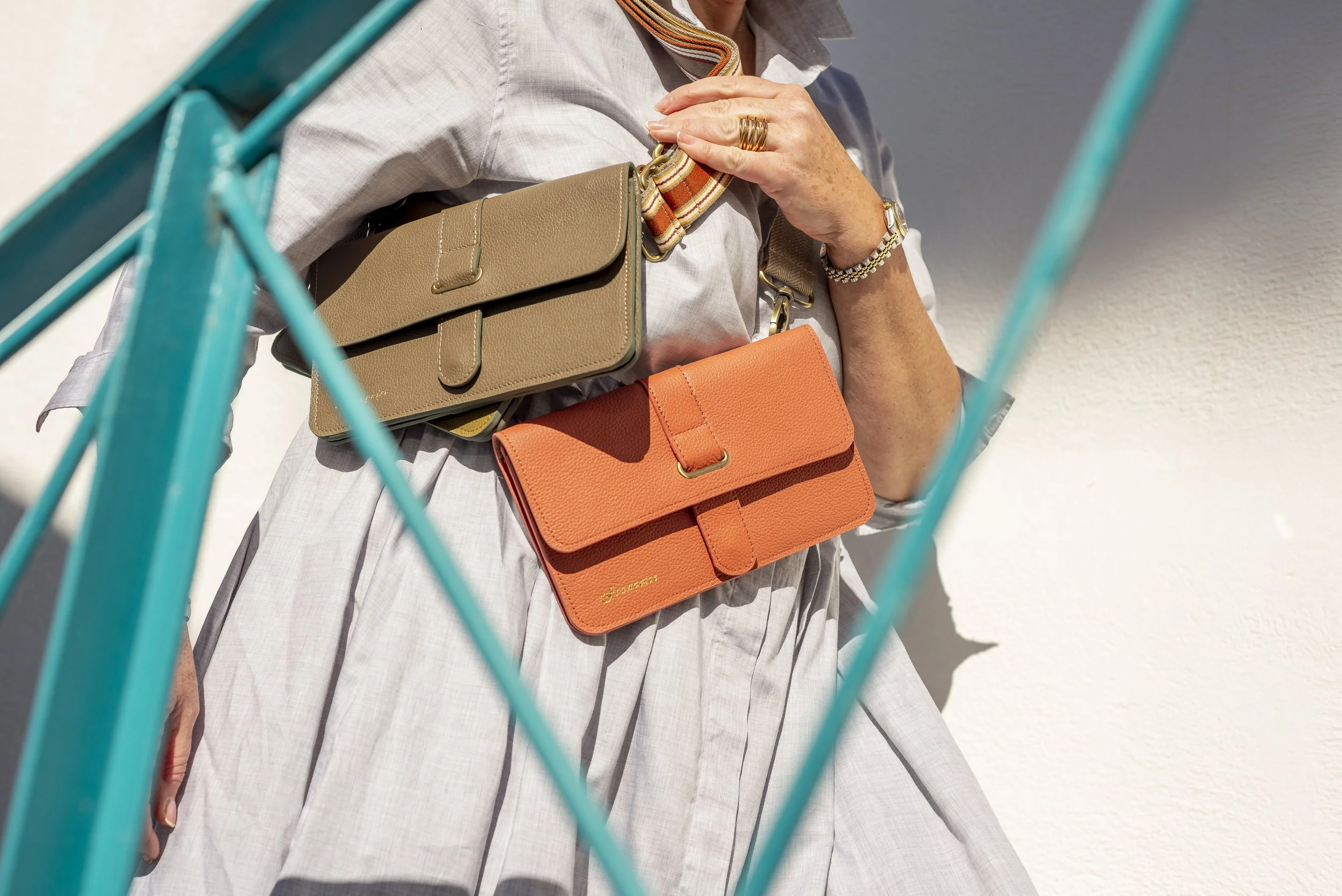 A woman wearing a white shirt, accessorised with jewellery, wearing two Francoise City bags over her shoulder.