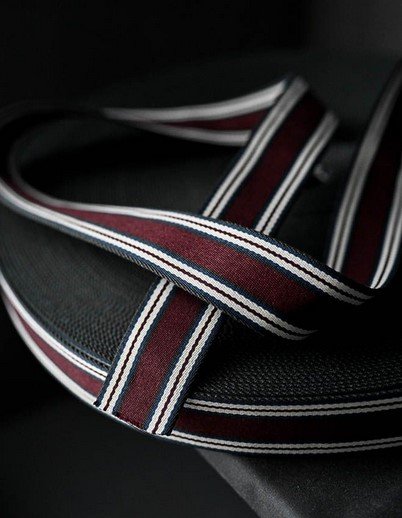 Close-up of a black and dark red canvas belt.