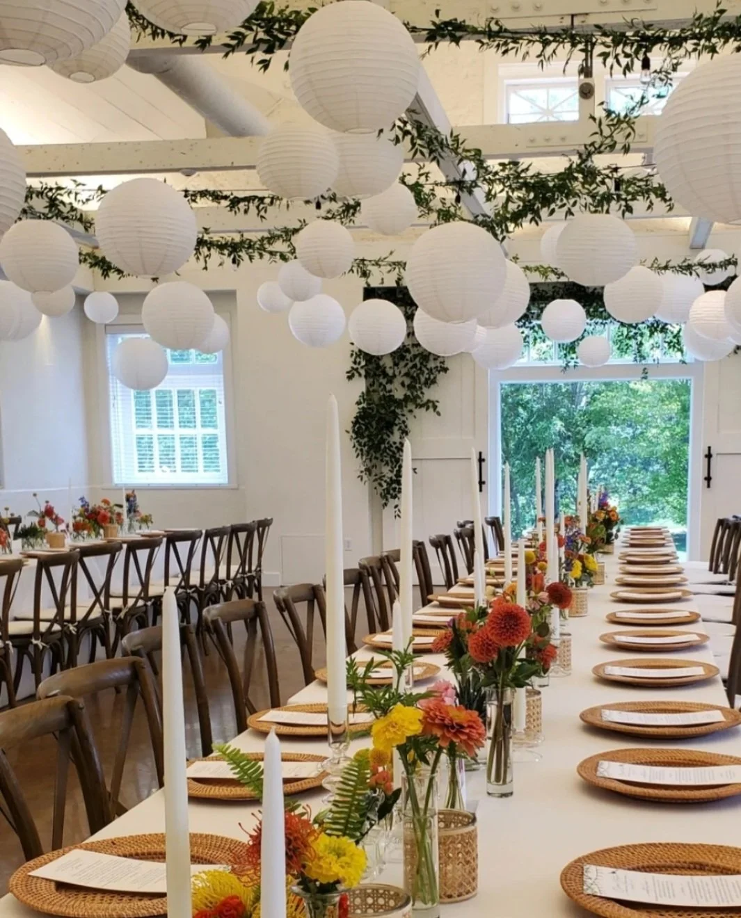 This version of the Barn at Reynolda had Italian Ruscus that we strung on heavy gauge wire and looped across the ceiling and then we added 5 sizes of paper lanterns in the design as well. If I remember correctly we had about 125 paper lanterns that w