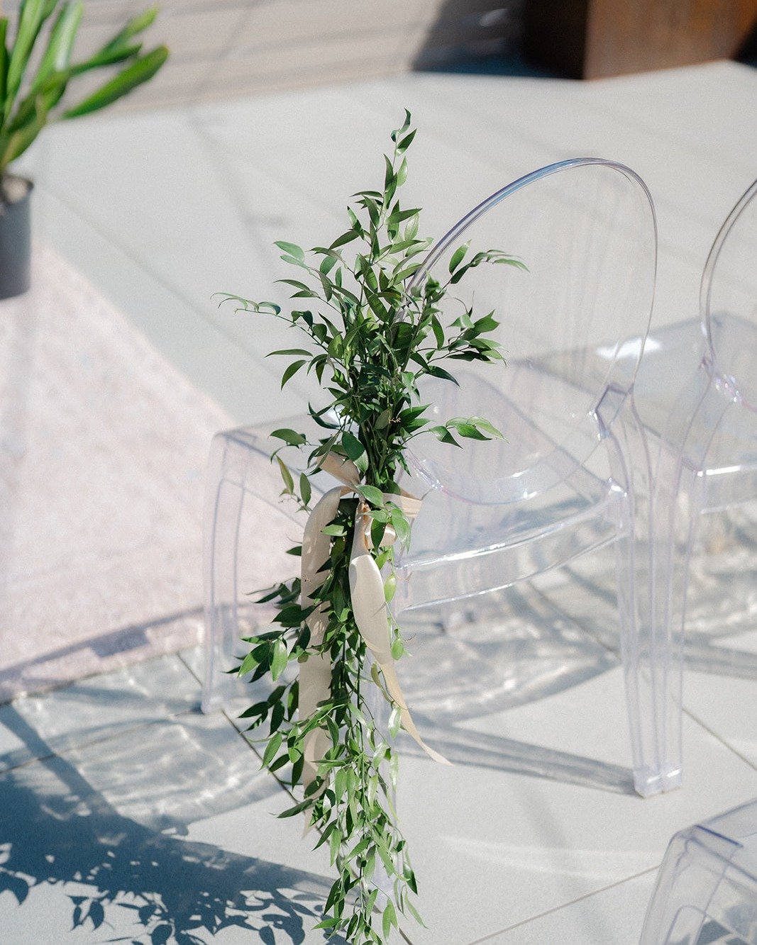 Ghost chair with ruscus greenery. Ruscus always makes the perfect addition down the aisle.