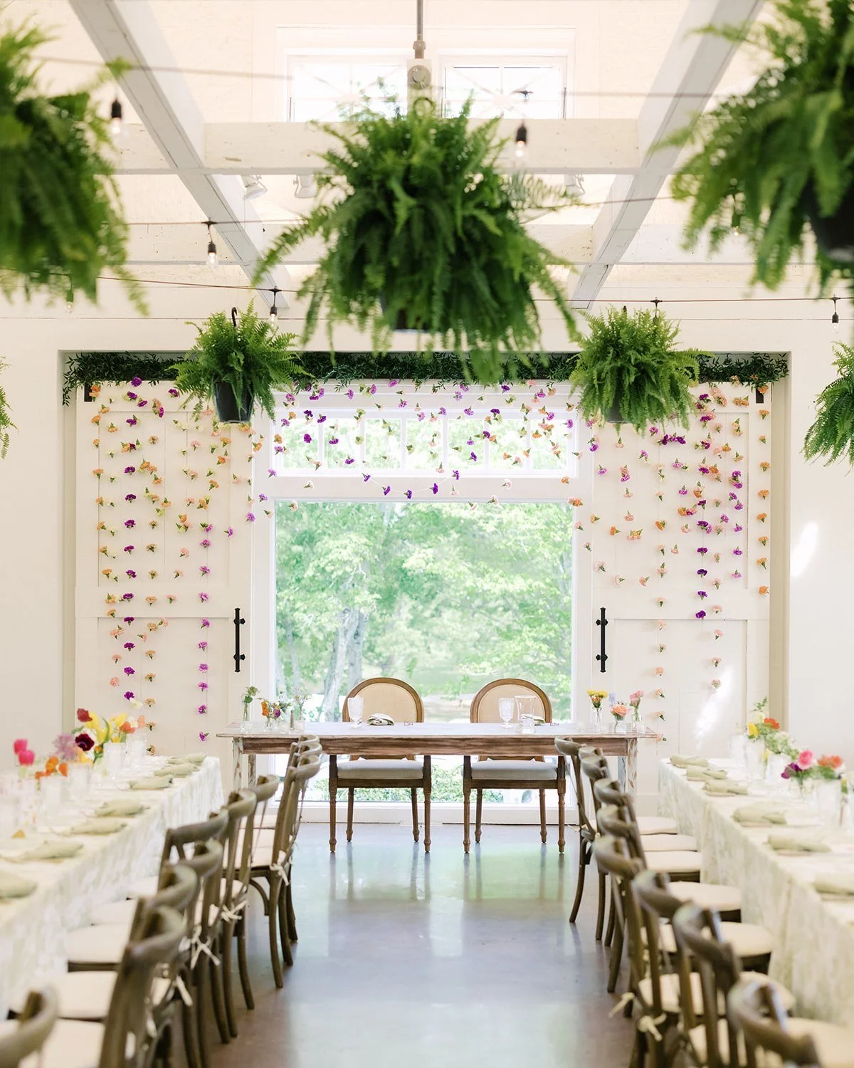 This Backdrop on the Barn doors at Reynolda was a fun twist on what we normally get to do for clients. On this iteration we utilized Italian Ruscus on the barn door roller mechanics and then strung multiple feet of carnations in varying colors and le