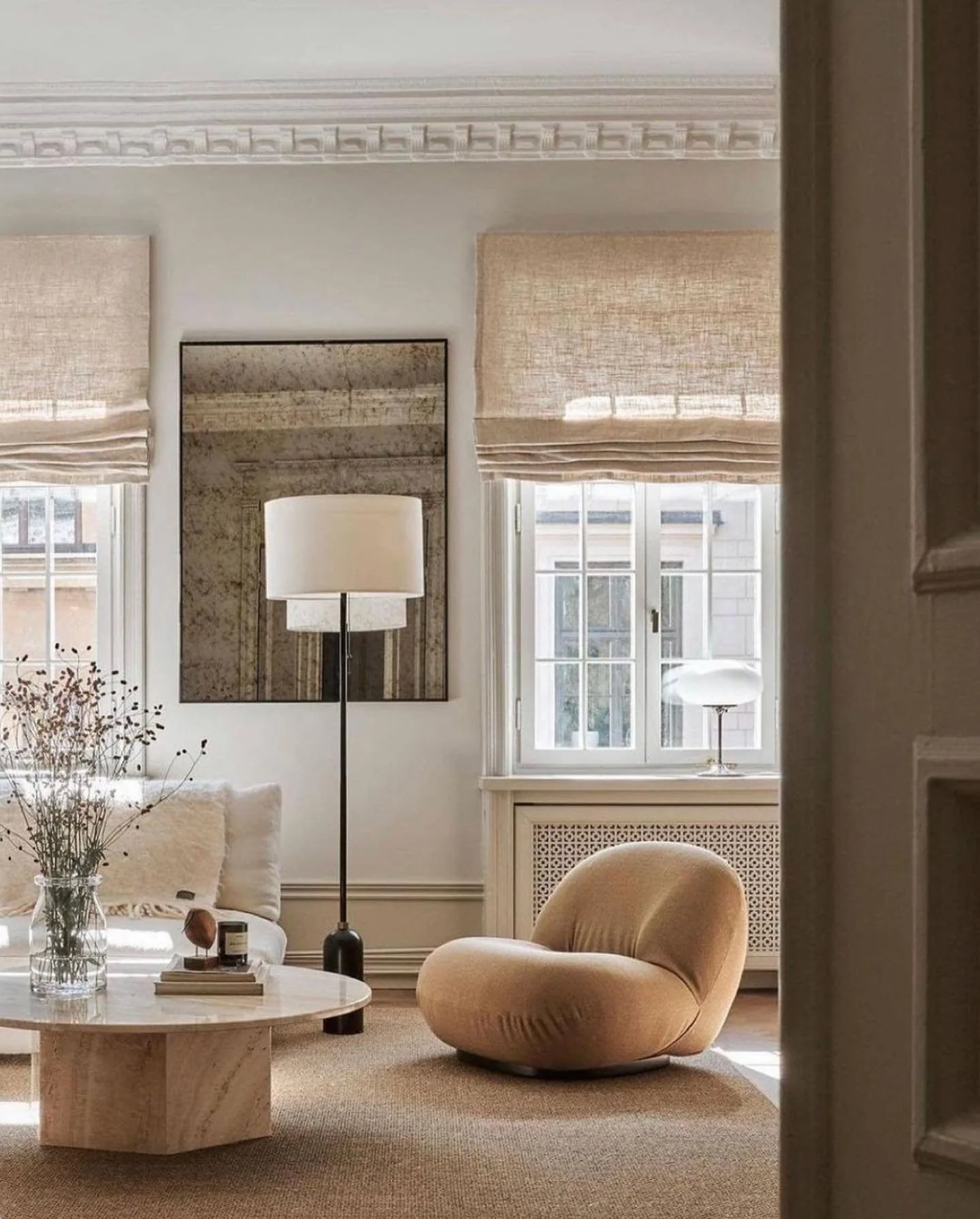 This designer use Pierre Paulin&rsquo;s Patcha Lounge Chair to add an organic shape and texture, while starkly contrasting that with the geometric form and cold texture of the  hexagonal stone coffee table. 

The antiqued mirror is balanced with a mo