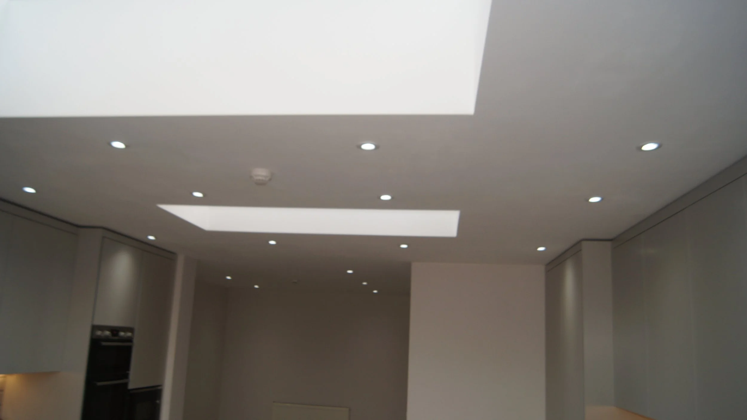 Interior view of a modern kitchen with recessed ceiling lights and skylights