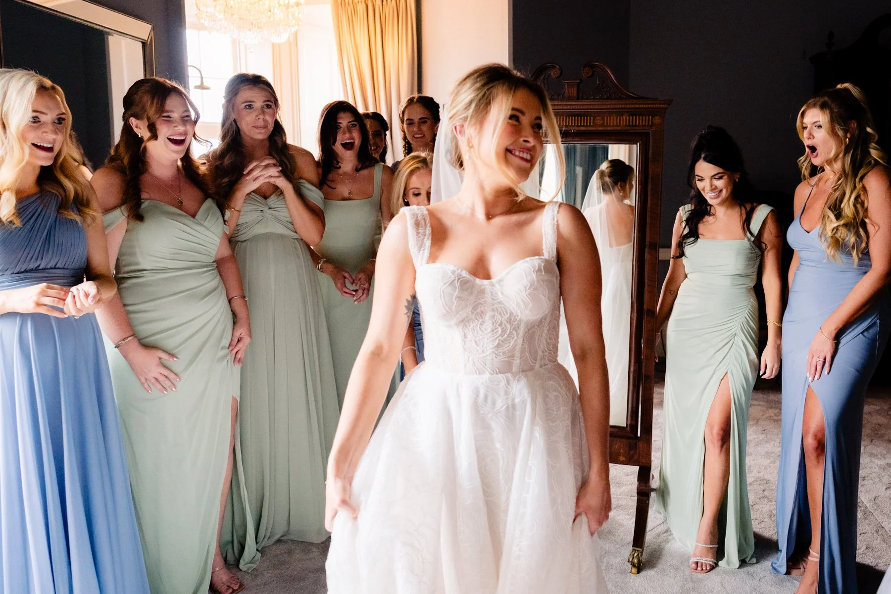 A classic wedding photography moment of the bridesmaids seeing the bride for the first time in the bridal suite at Luttrellstown Castle Dublin