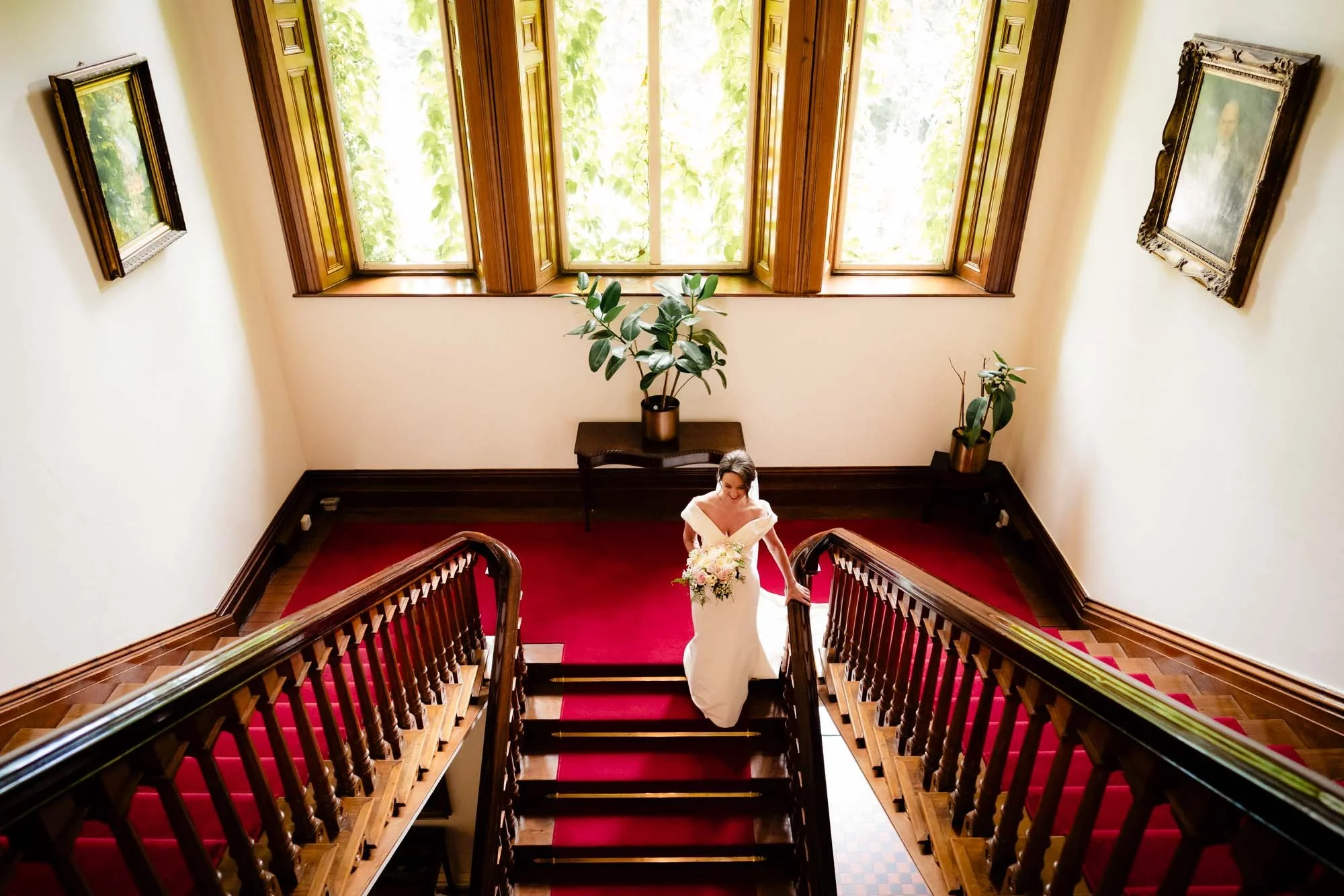 bride walking down grand staircase in tinakilly house