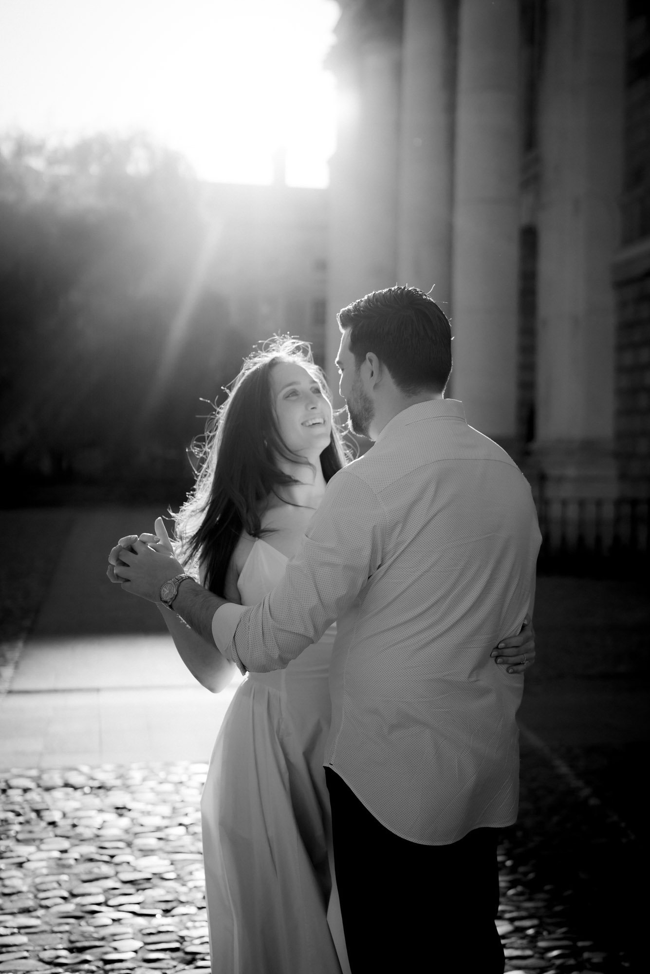 An american bride and groom in a black and white wedding photograph of them dancing in front square trinity college dublin