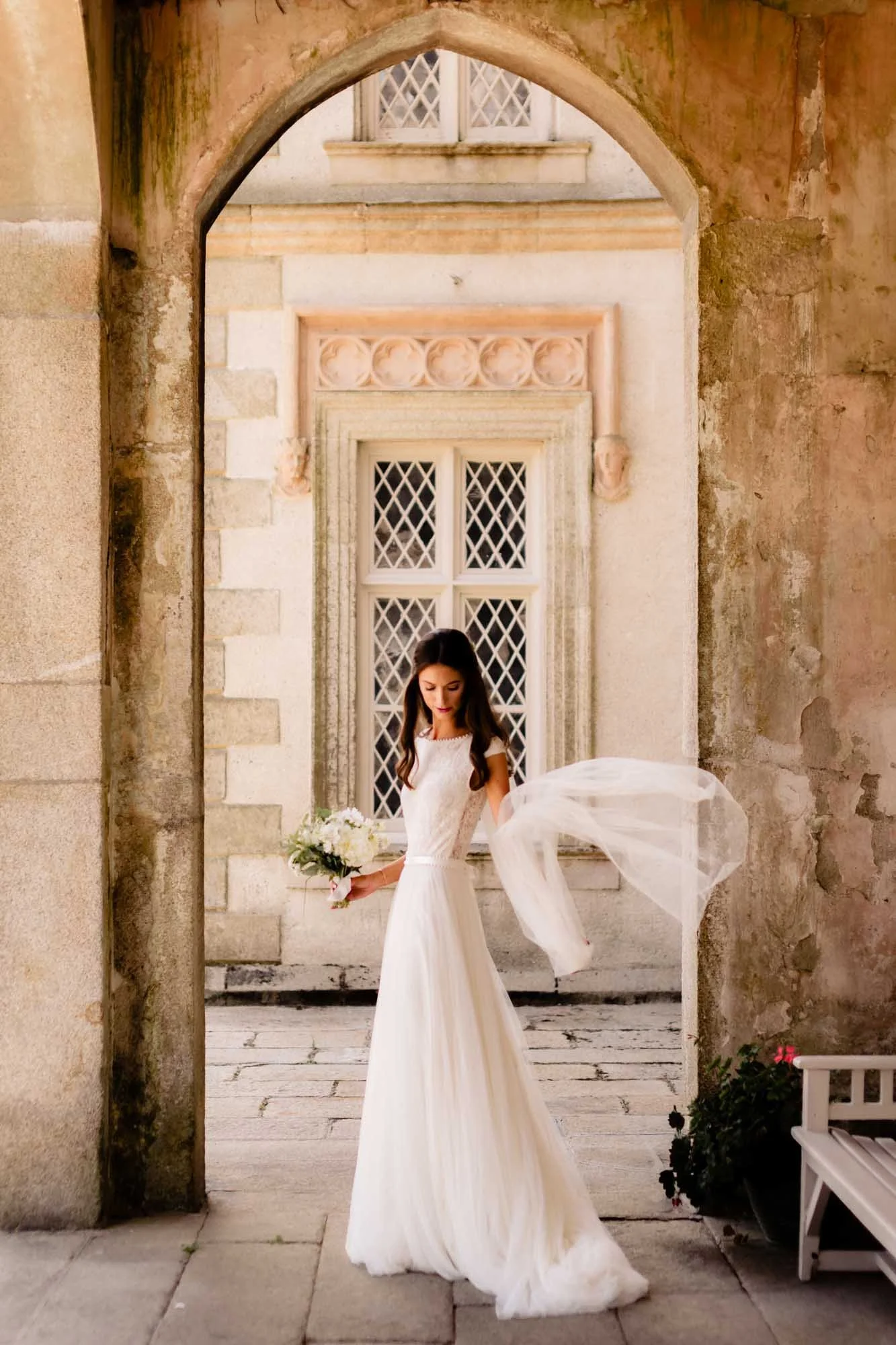 Bride poses outside Borris House while playing with her veil in a natural portrait