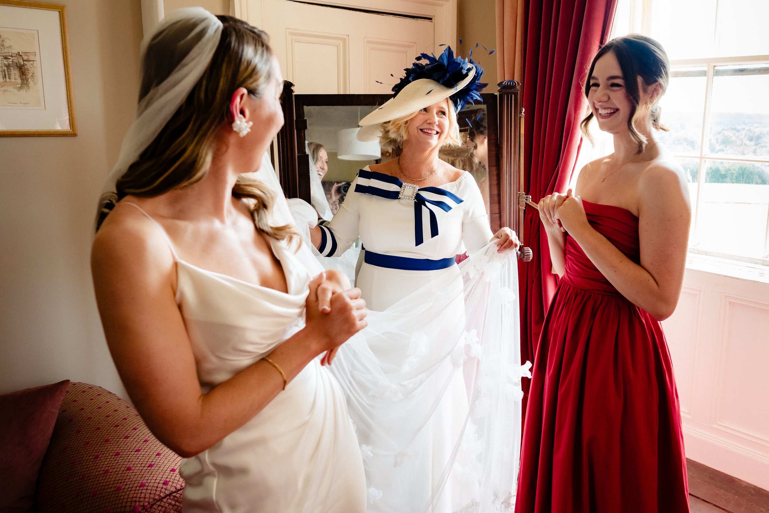 Beautifully lit wedding photography of the bride and her mother and sister getting ready in the bridal suite at Borris House