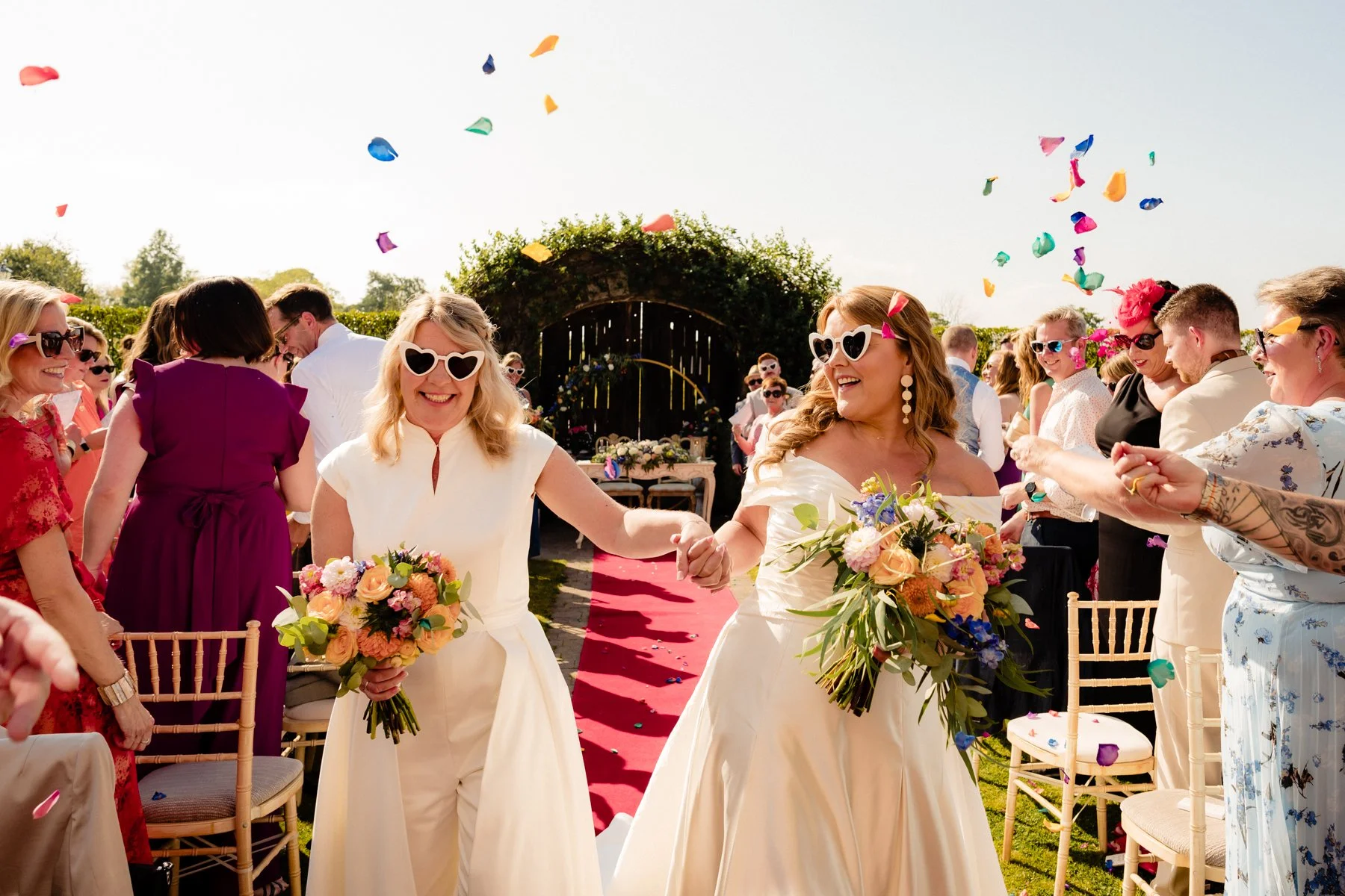 A confetti exit wedding photograph for a same sew wedding ceremony at Ballymagarvey Village with two brides