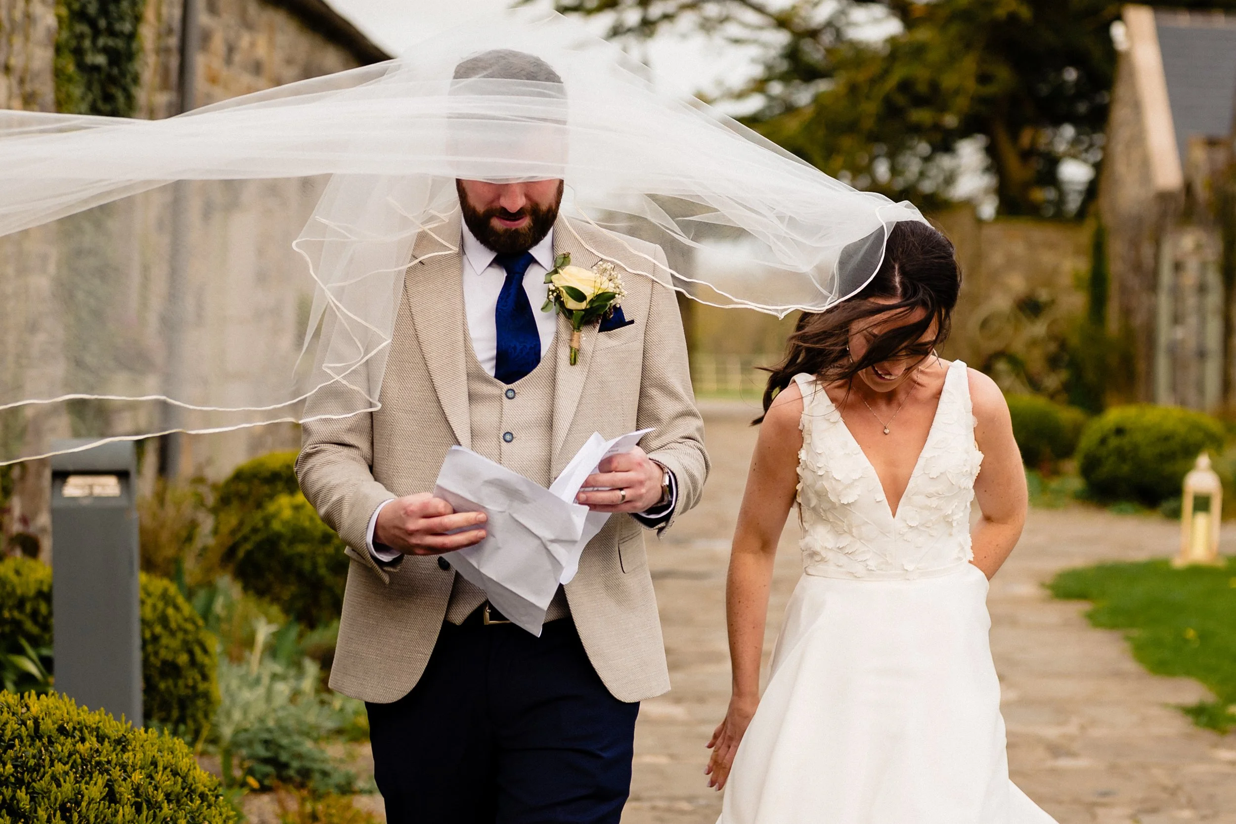 A joyful little moment of the bride's veil covering the groom in Ballymagarvey wedding photography