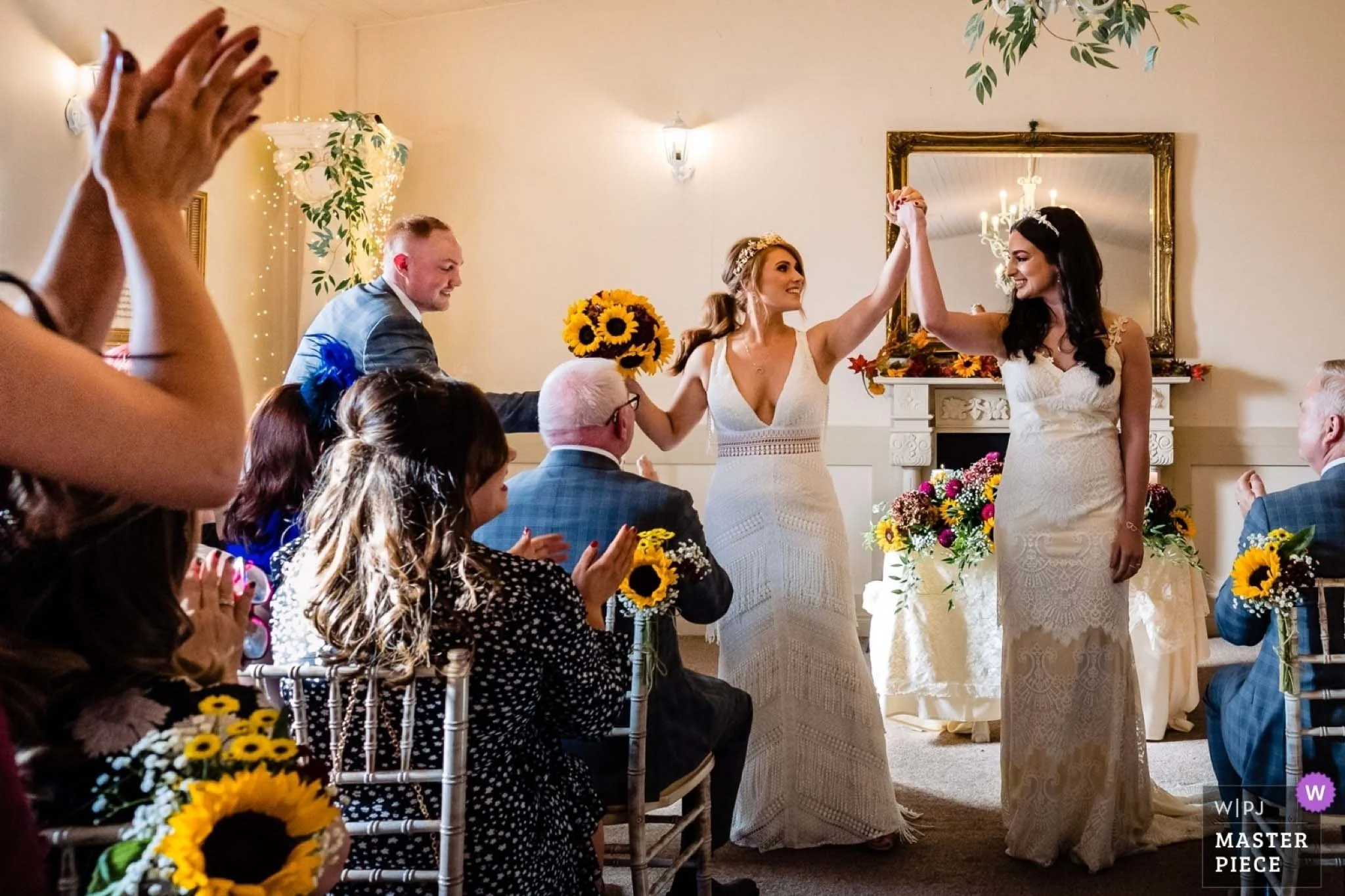 wedding photo of two brides cheering as they just got married in Darver Castle