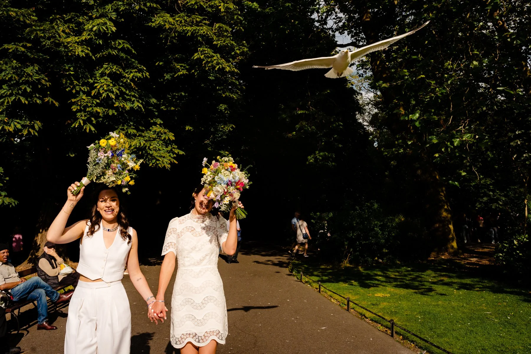 Wedding photography of two brides strolling through St Stephen's Green on their wedding day in Dublin