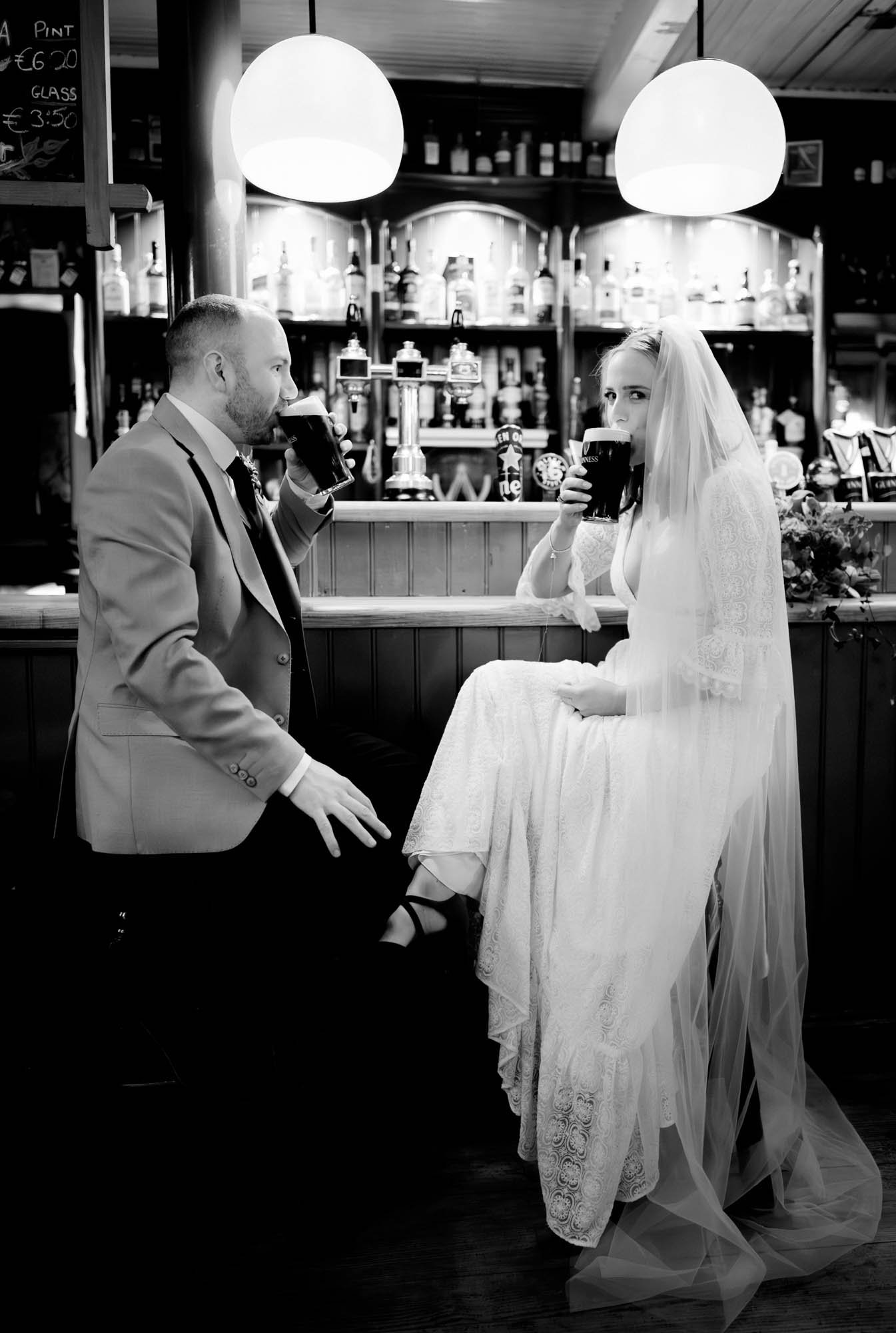 A relaxed black and white wedding photograph of a bride and groom in Actons pub on their BrookLodge wedding day