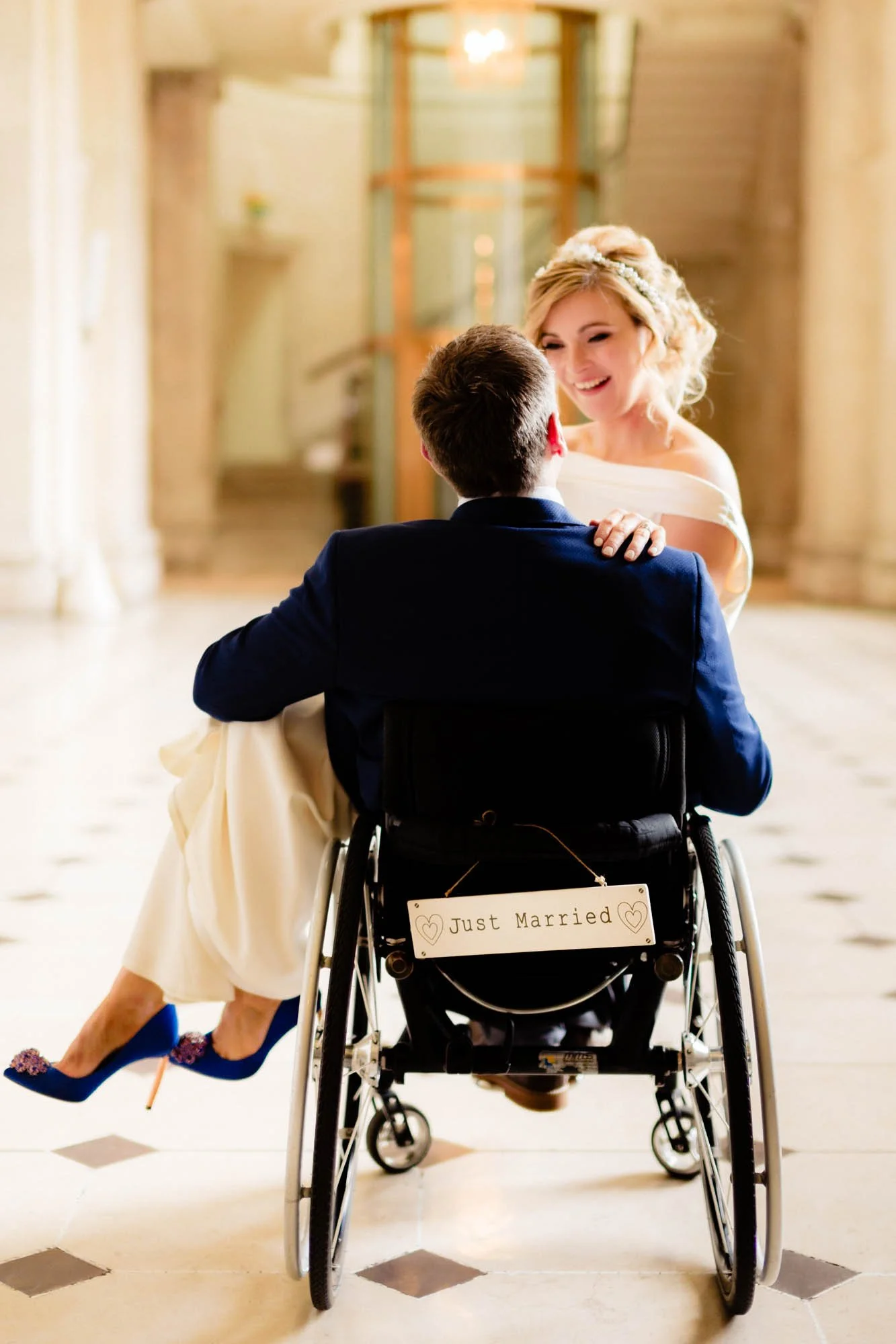 Wedding photograph of a groom in a wheelchair with his bride on his lap in Dublin City Hall