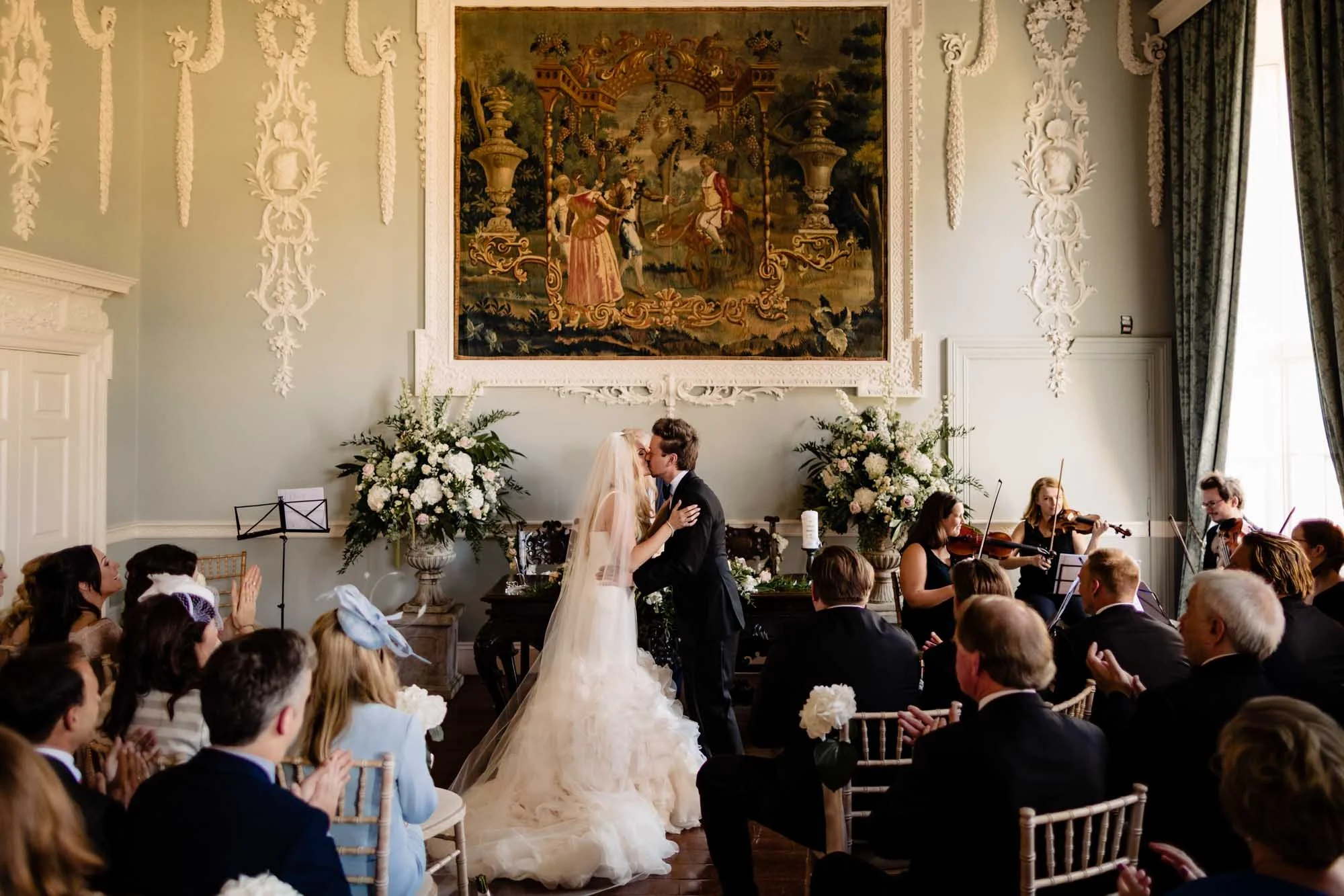 Wedding photograph of the first kiss during an indoor wedding ceremony at Luttrellstown Castle