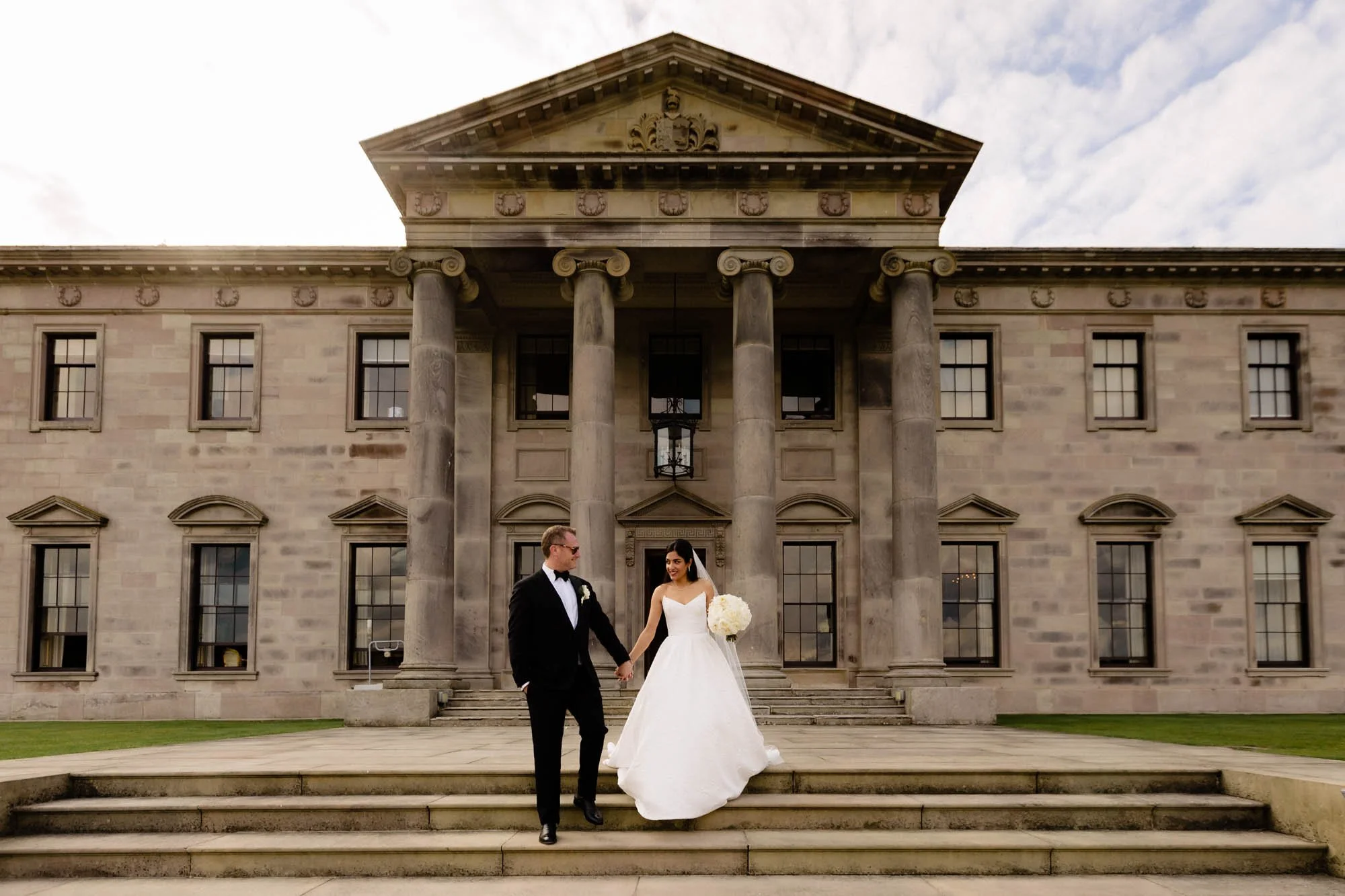 American bride and Irish groom pose outside Ballyfin Demesne after their destination wedding in Ballyfin, Ireland