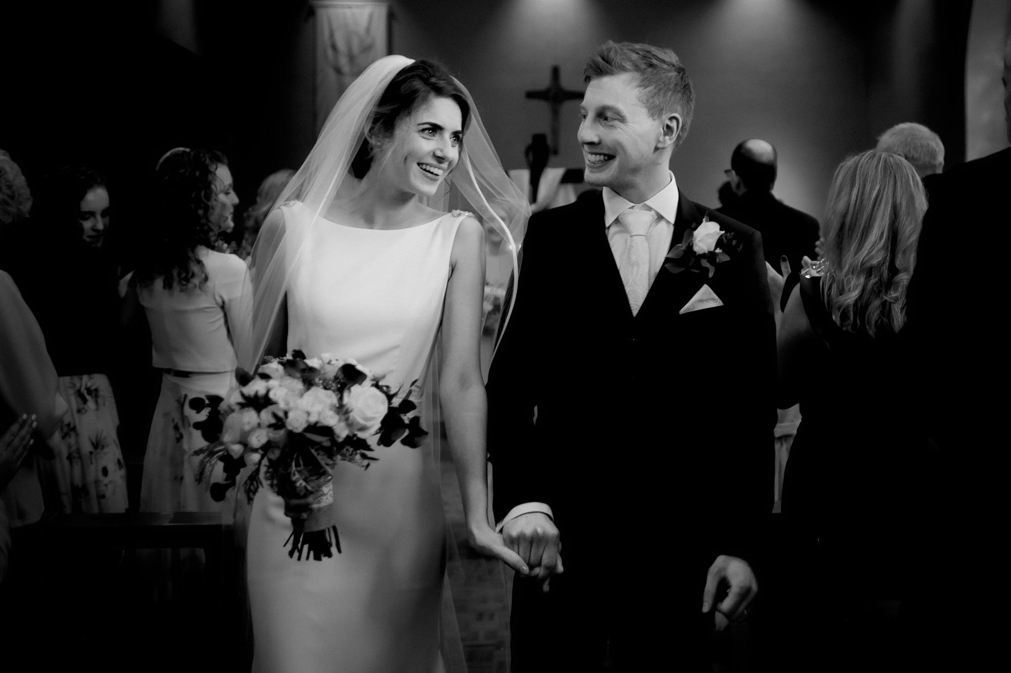 The groom glances at his beautiful bride as they exist their wedding ceremony at the Cliff at Lyons