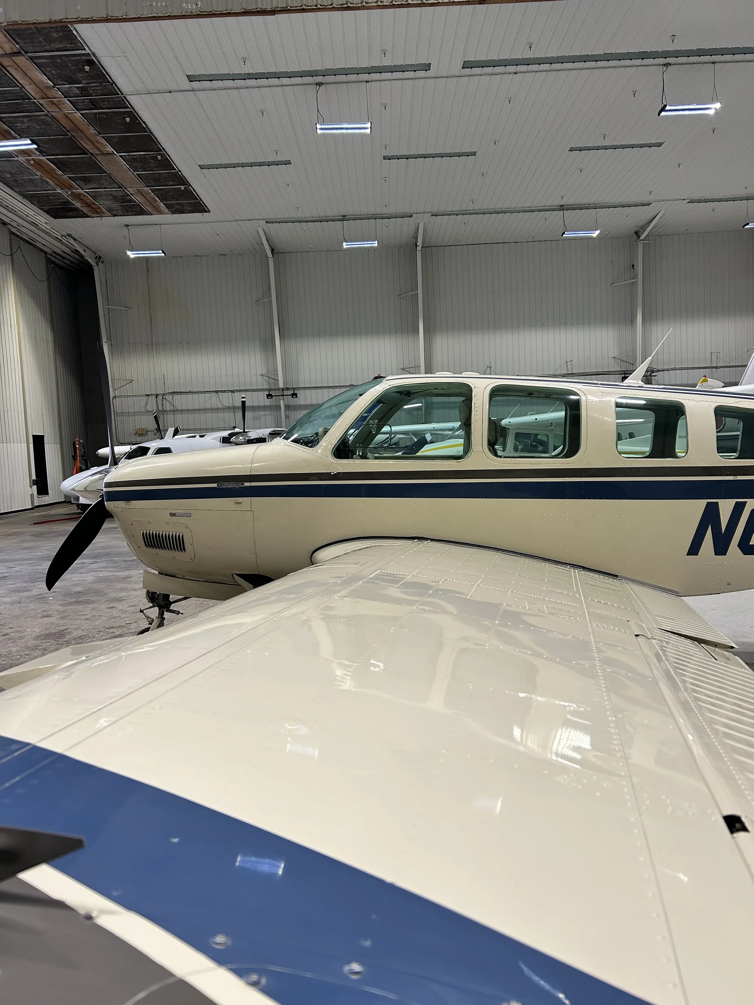 A small propeller airplane parked inside a hangar after being washed and cleaned by Pure Aviation Detailing at 5m5 Dixon Airport in Decatur, Arkansas