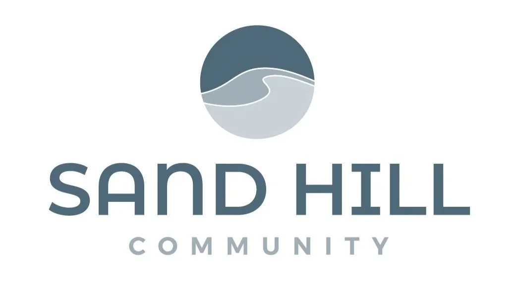 Logo for Sand Hill Community, featuring a circular icon with stylized waves and a hillside, and the text "Sand Hill Community" beneath it.